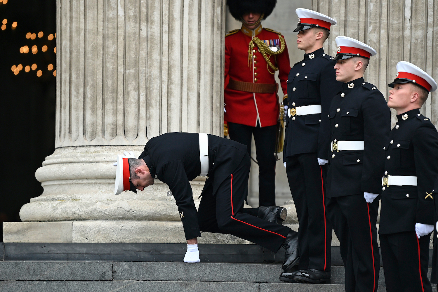 A member of the military stumbles while on duty ahead of a service of thanksgiving for the reign of Queen Elizabeth II. Photo / AP