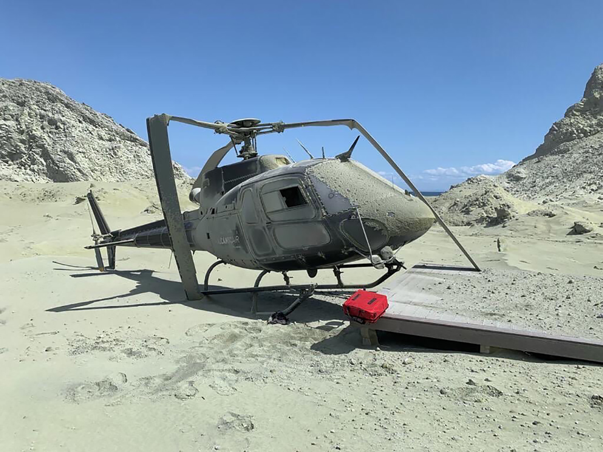 The force of the volcanic eruption blasted a helicopter off its landing pad, breaking its rotor blade.