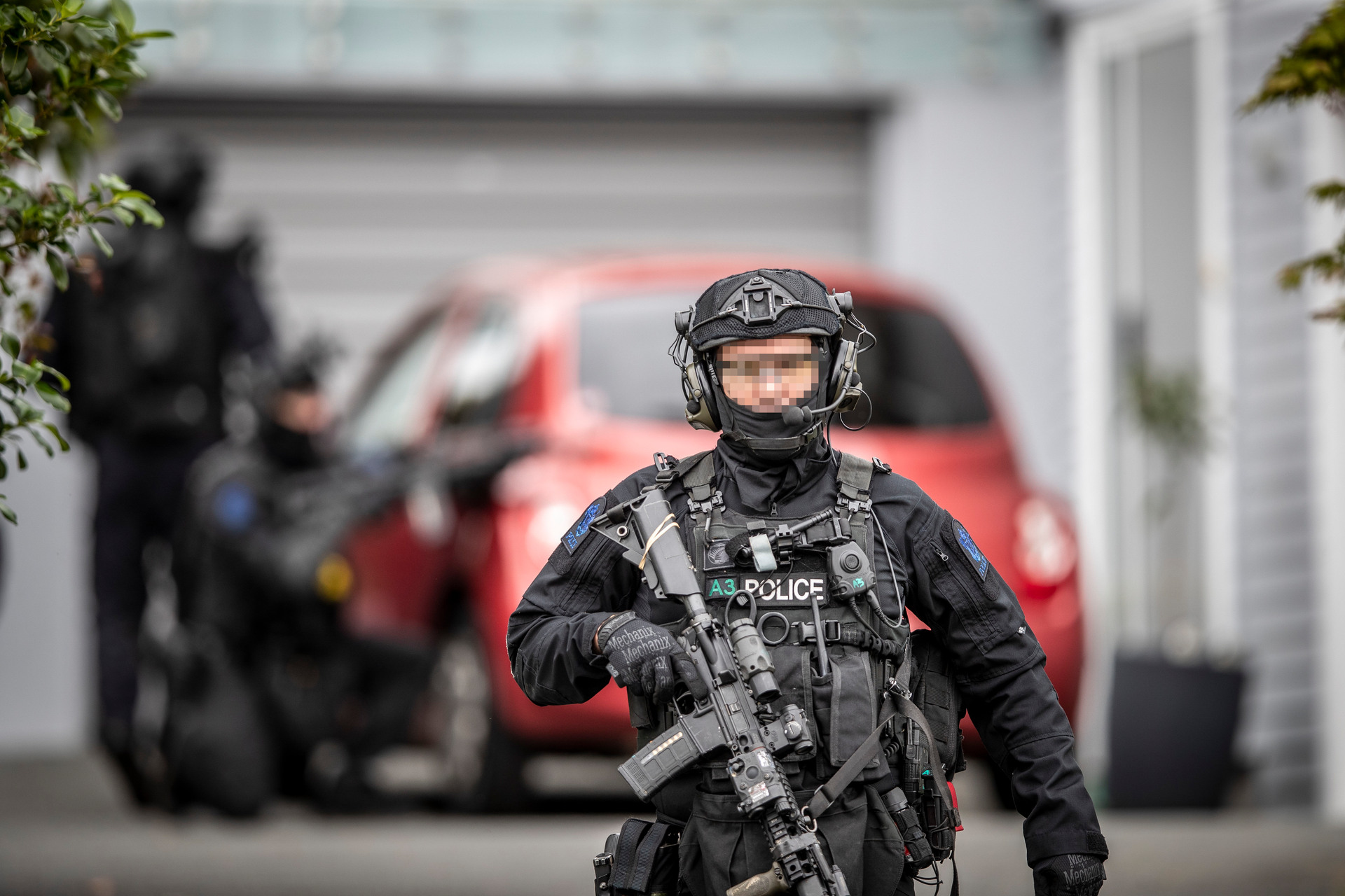 Armed police search Cliffview Rd, Green Bay, after an earlier homicide at the New Haven Motel, New Lynn. Photo / Michael Craig