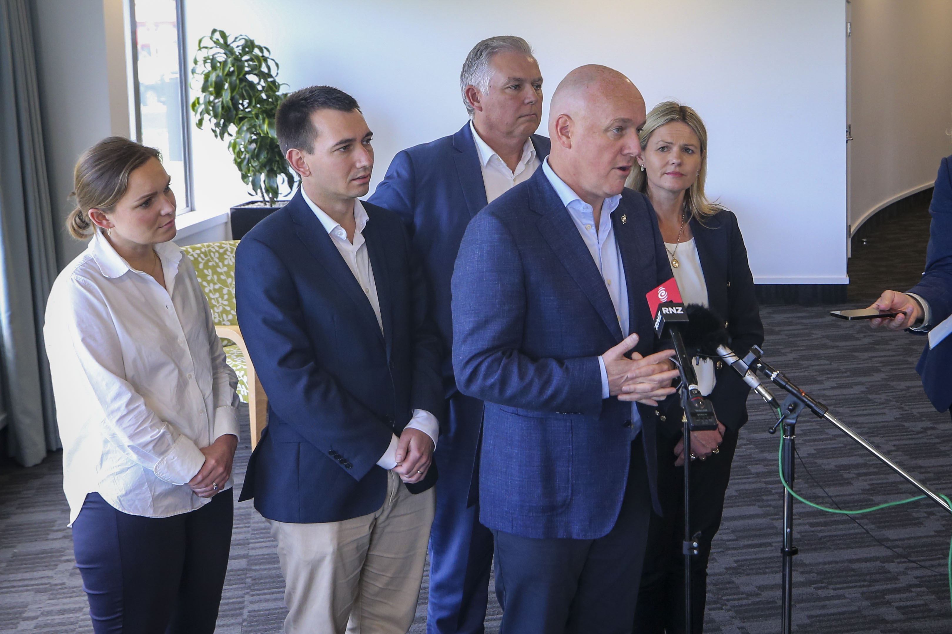 Luxon speaks to media at Napier War Memorial on Friday, along with Cyclone Recovery Minister Mark Mitchell, Transport Minister Simeon Brown and local MPs Katie Nimon for Napier and Catherine Wedd for Tukituki. Photo / Paul Taylor