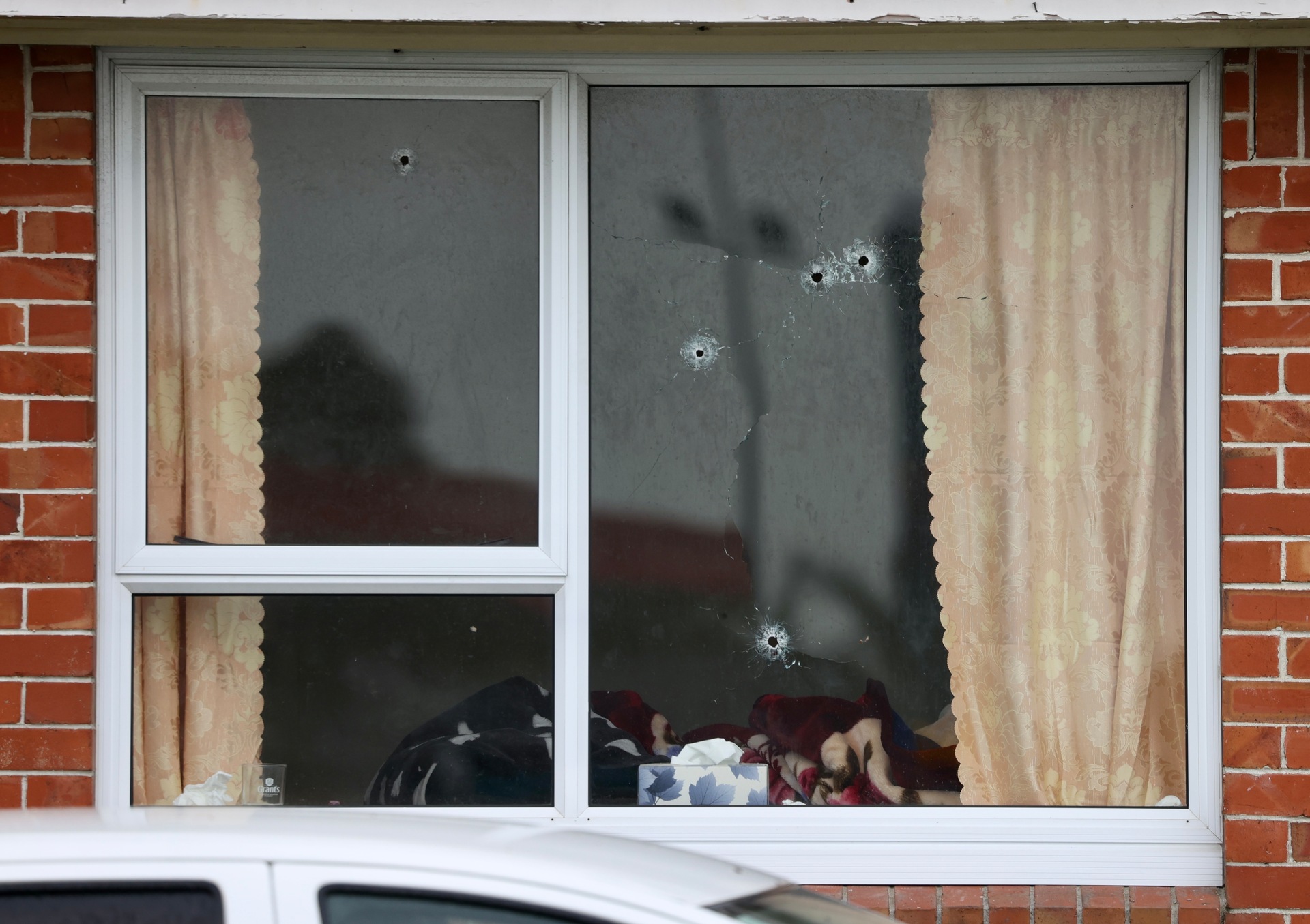 A Manukau home's front window is left riddled with bullet holes after a drive-by shooting overnight. Photo / George Heard