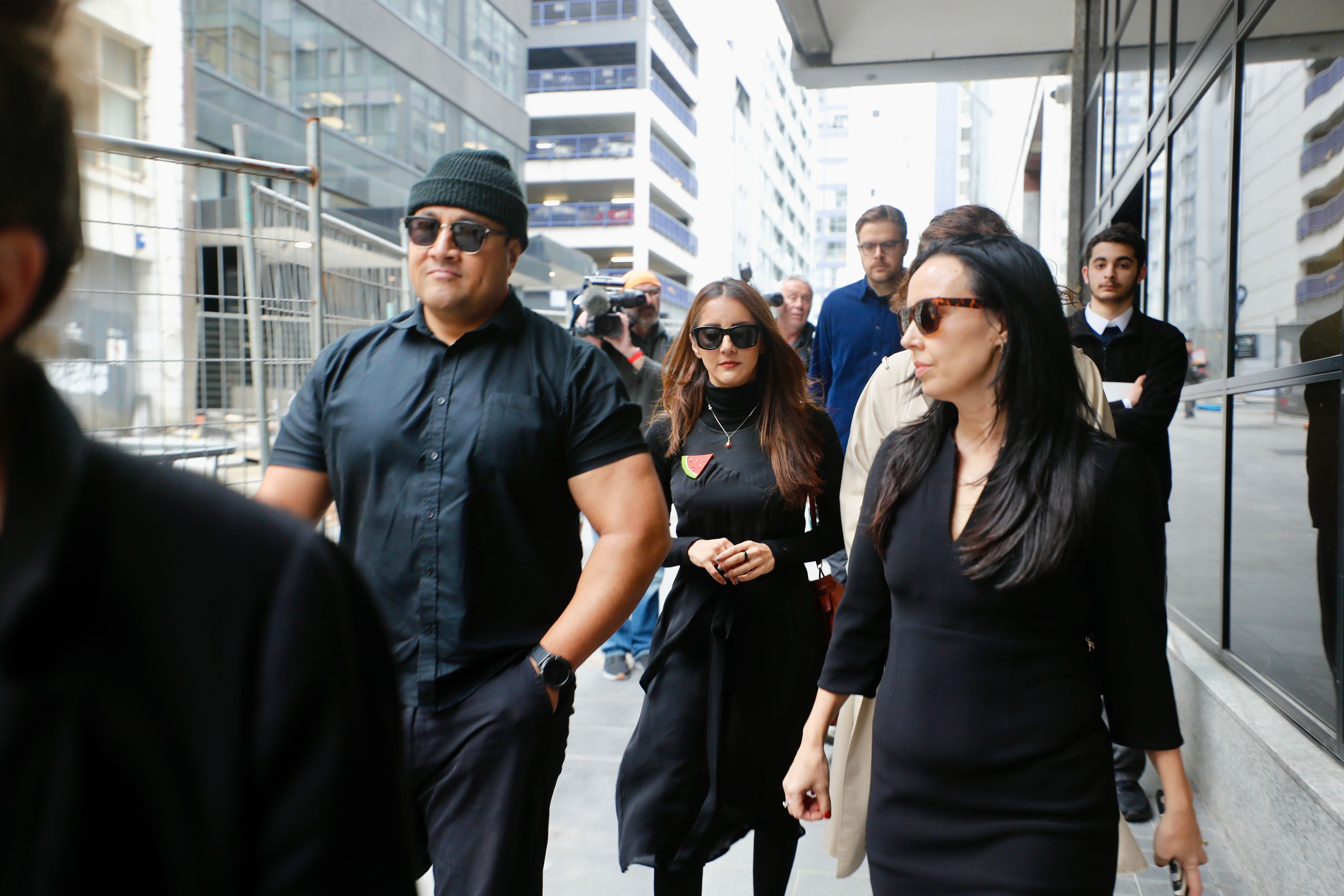 Former Green MP Golriz Ghahraman arrives at Auckland District Court for sentencing, flanked by supporters including her ex-partner Guy Williams. Photo / Dean Purcell