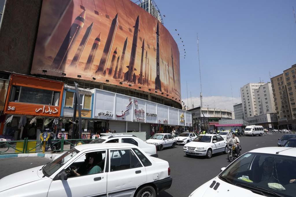 Vehicles drive past an anti-Israeli banner showing missiles being launched, in a square in downtown Tehran, Iran on April 19. Photo / AP