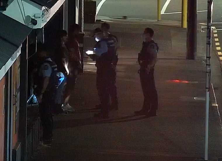 Four police officers arrive to speak with Jamie Lawry and the man in the burgundy shirt. Lawry was found not guilty of resisting arrest, disorderly behaviour and assault almost four years later.