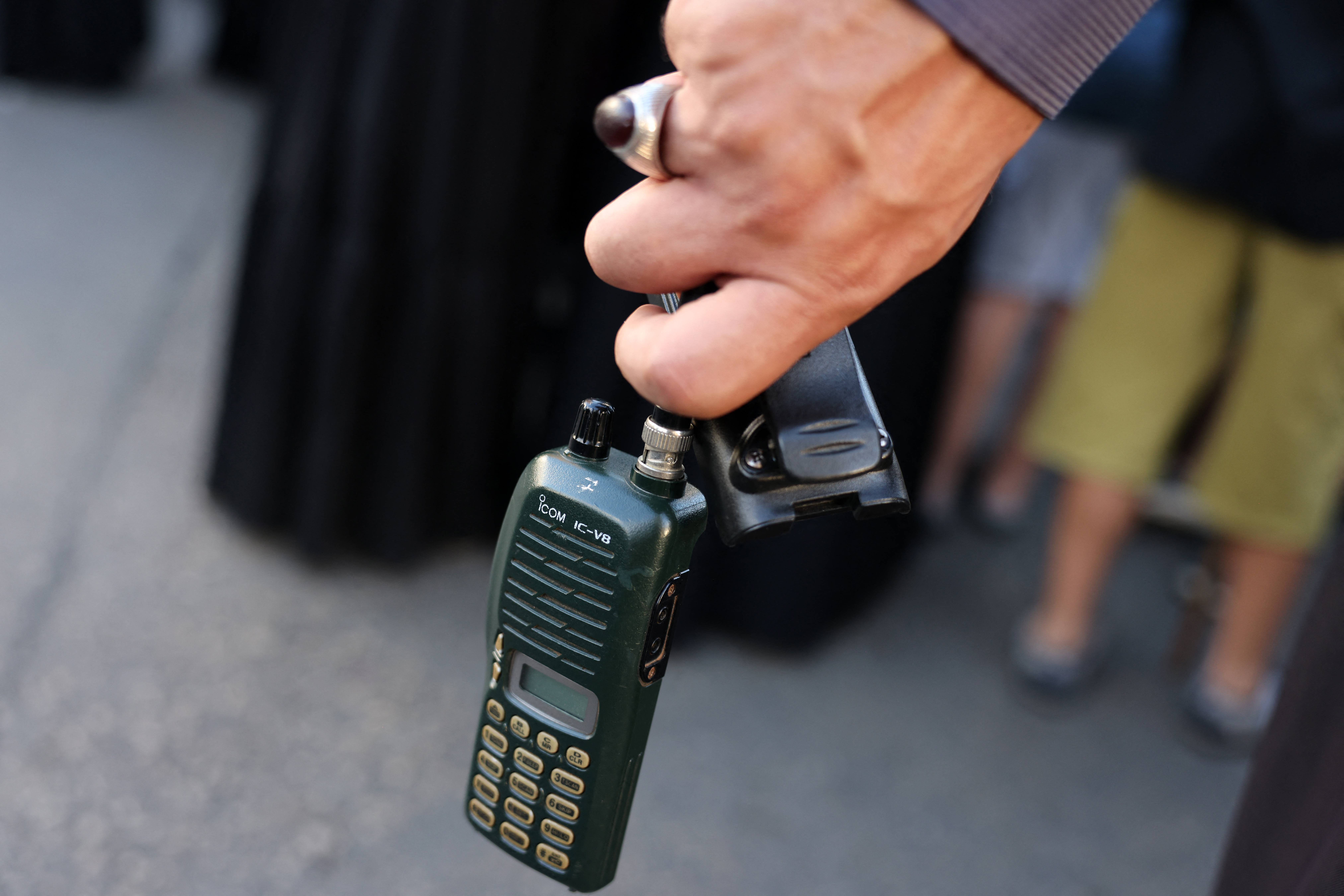 A man holds a walkie talkie device after he removed the battery during the funeral of persons killed when hundreds of paging devices exploded in a deadly wave across Lebanon the previous day, in Beirut's southern suburbs. Photo / AFP