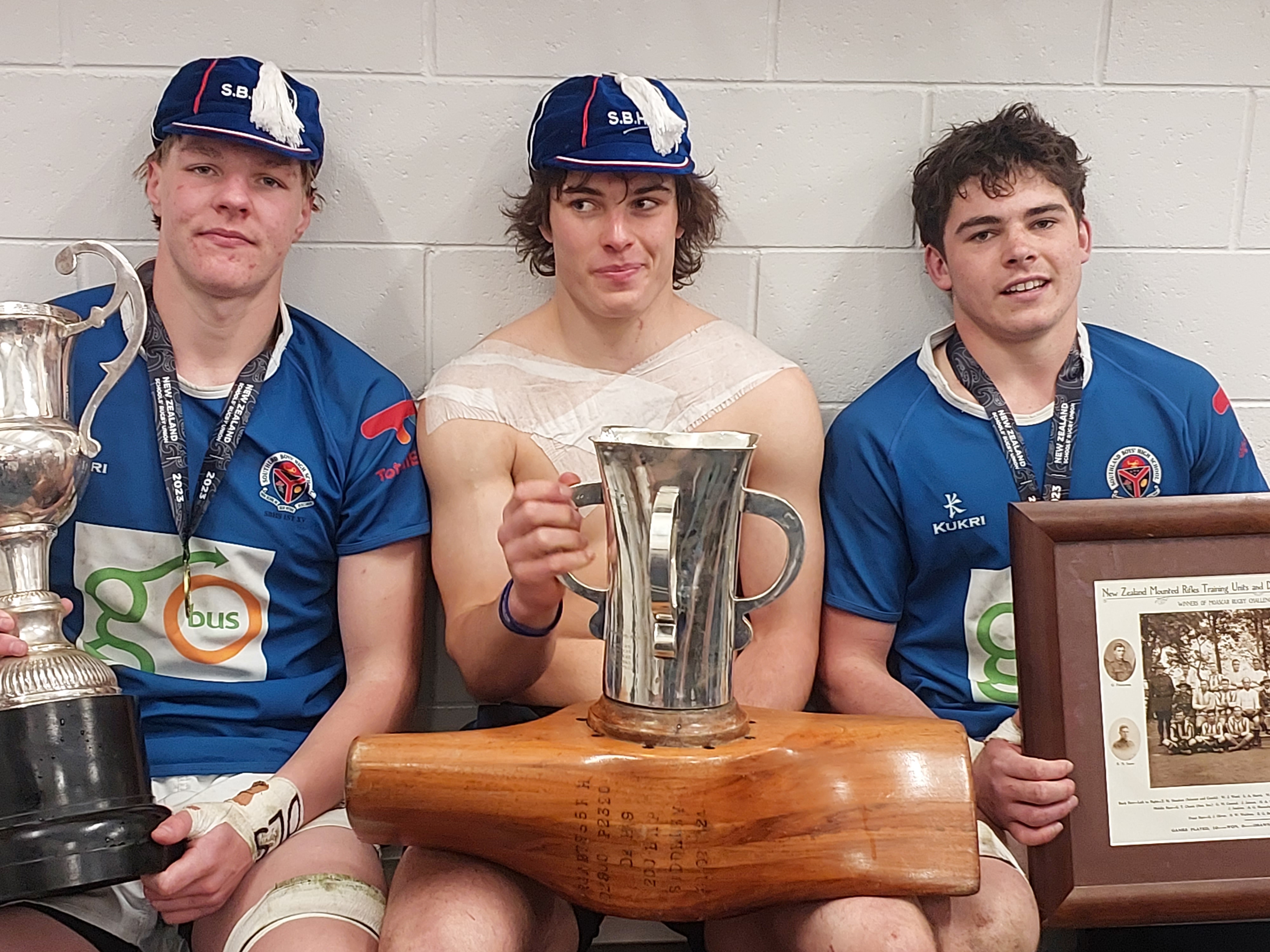 Southland Boys High players (from left) Justin Shaw, captain Gregor Rutledge and Lachie Riley with the National First XV Trophy and the Moascar Cup.