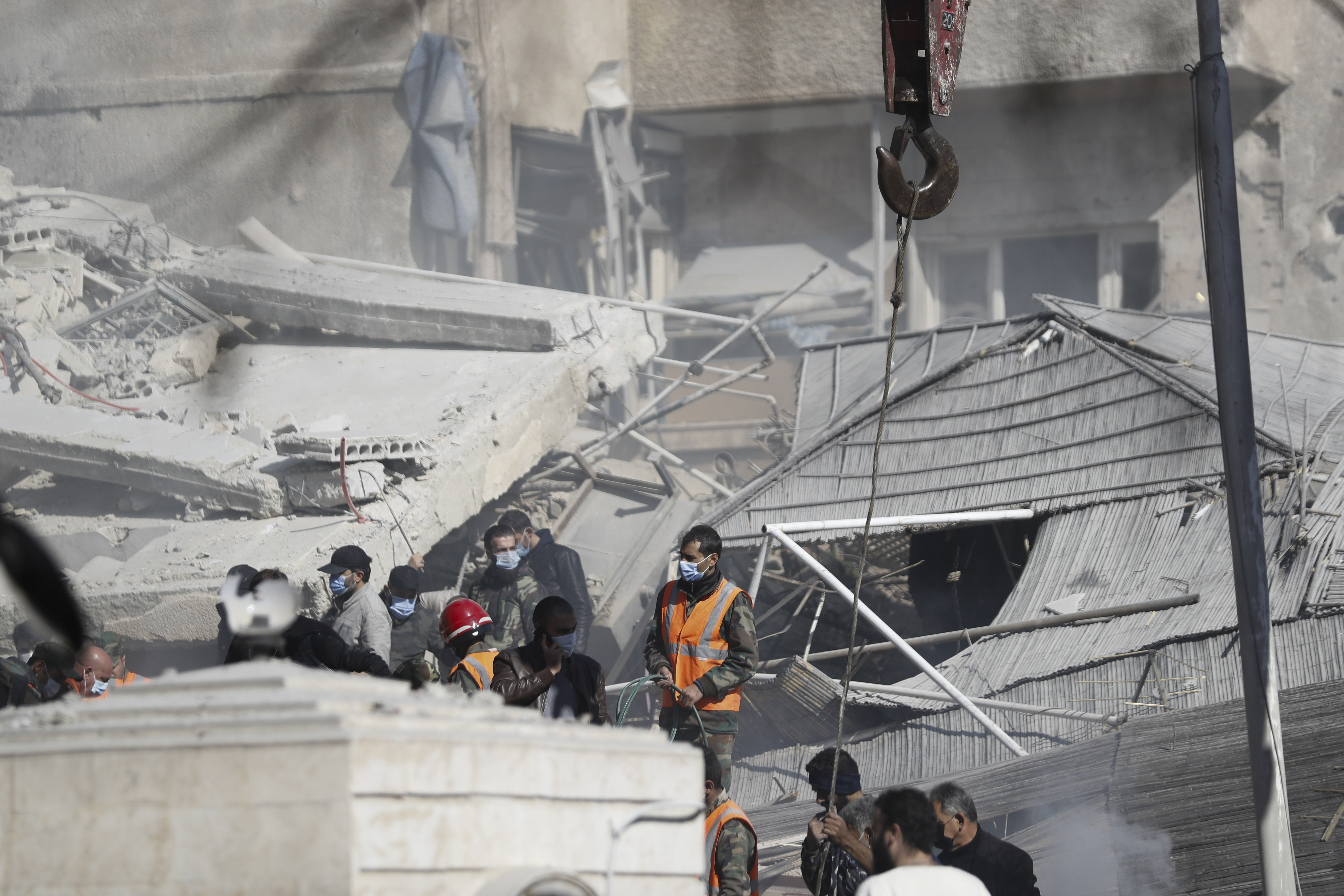 Emergency services work at a building hit by an air strike in Damascus, Syria. Photo / AP