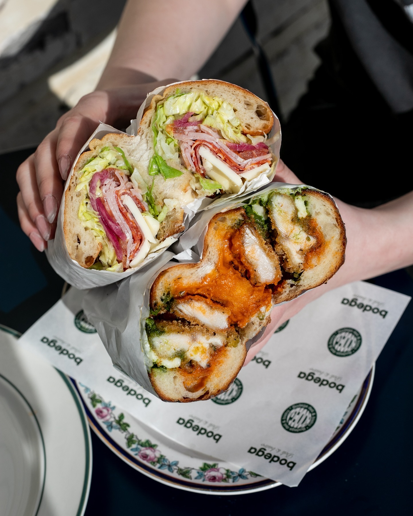 Bodega's vodka chicken sandwich and its namesake Bodega sandwich. Photo / @Bodega_akl