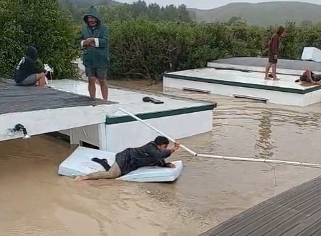 Workers at an orchard on the banks of the Tutaekuri River in Hawke's Bay have been forced onto roofs as flood waters leave them stranded. Photo / Lie Tu'imoala