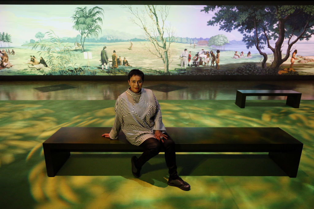 Lisa Reihana sits before her work 'In pursuit of Venus [infected]' during a press view for Oceania at the Royal Academy, London. Photo / Getty Images