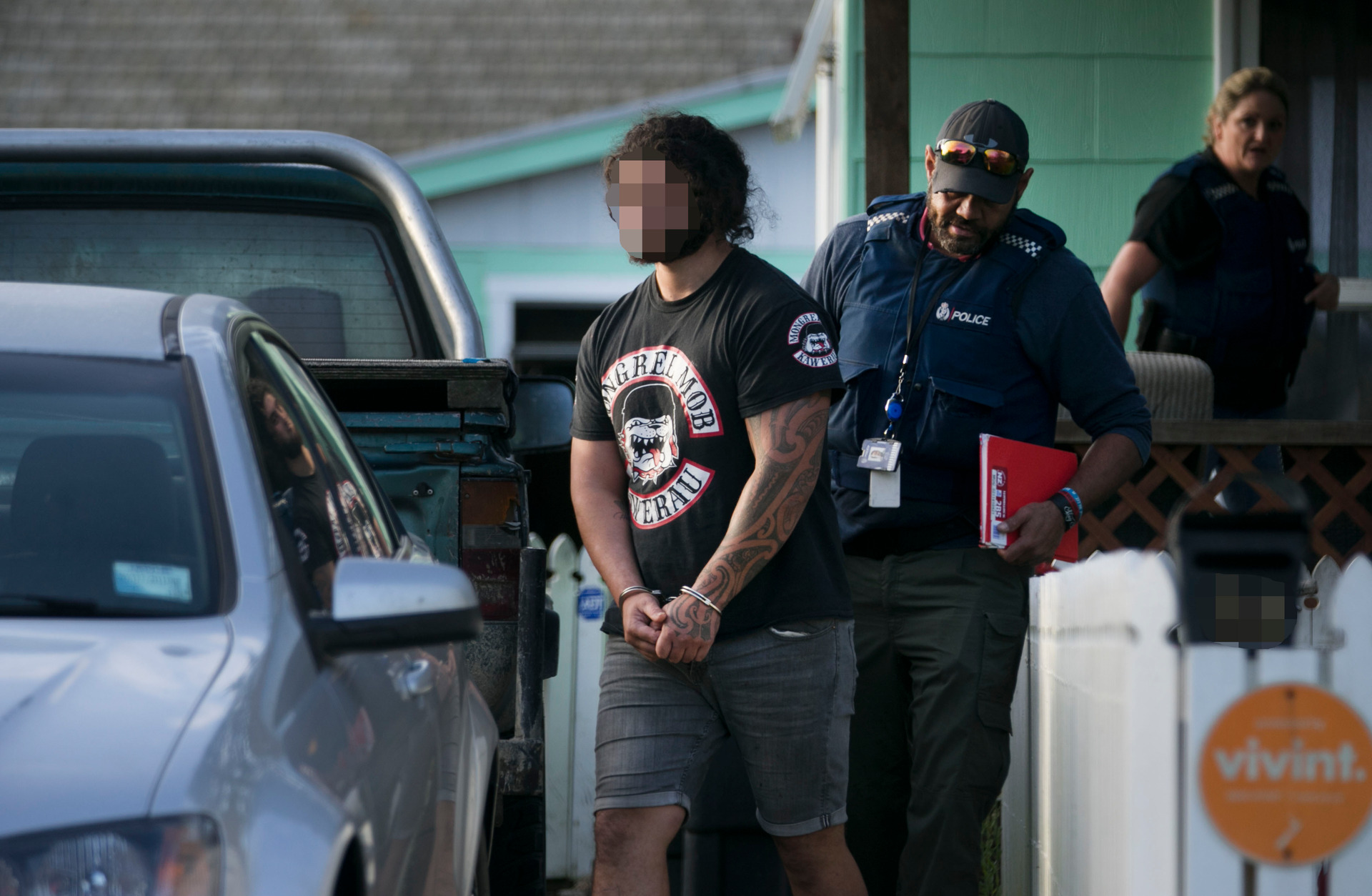 Police lead away a Mongrel Mob gang member during Operation Notus in 2018. Photo / Alan Gibson