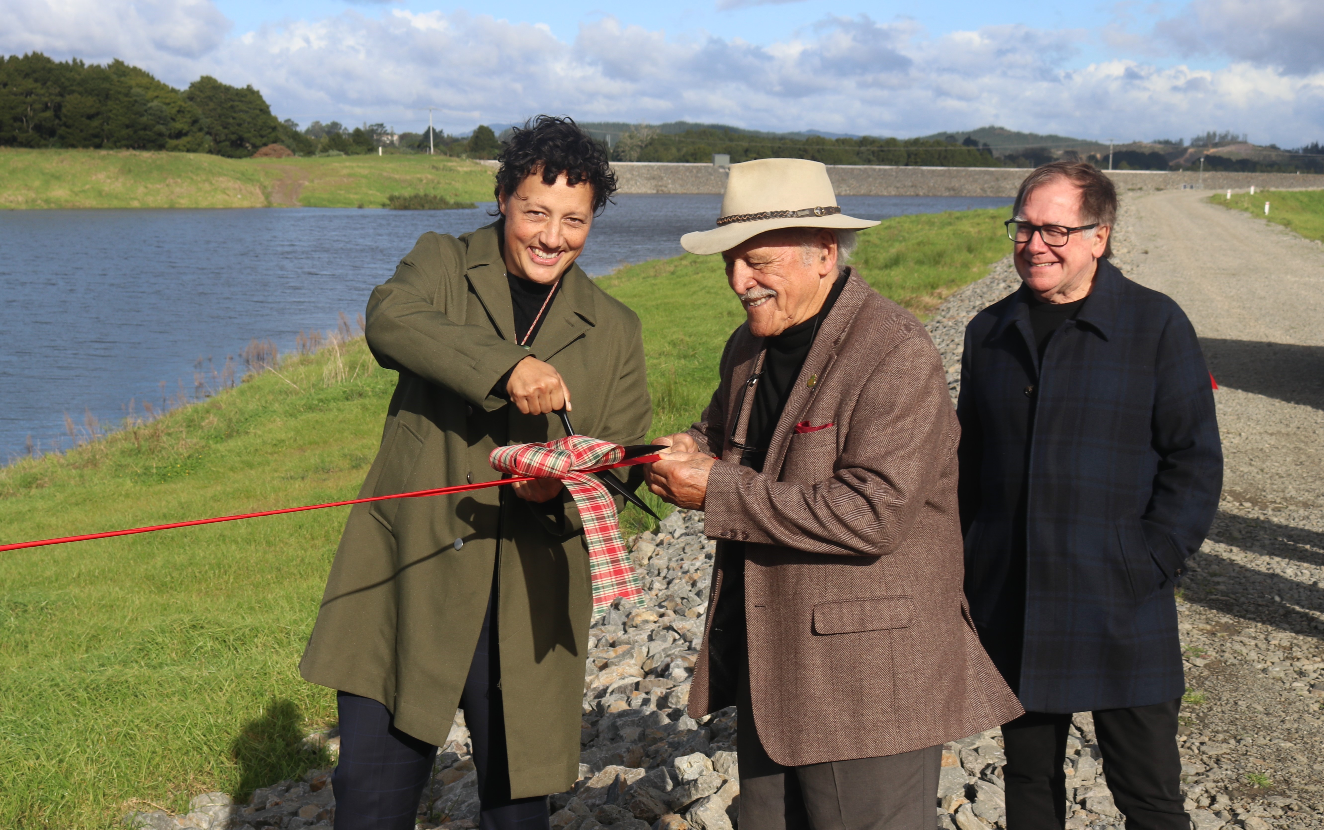 Regional Development Minister Kiritapu Allan cuts the Matawii Dam ribbon while Te Tai Tokerau Water trustee Dover Samuels lends a hand and trust chairman Murray McCully watches on. Photo / Peter de Graaf