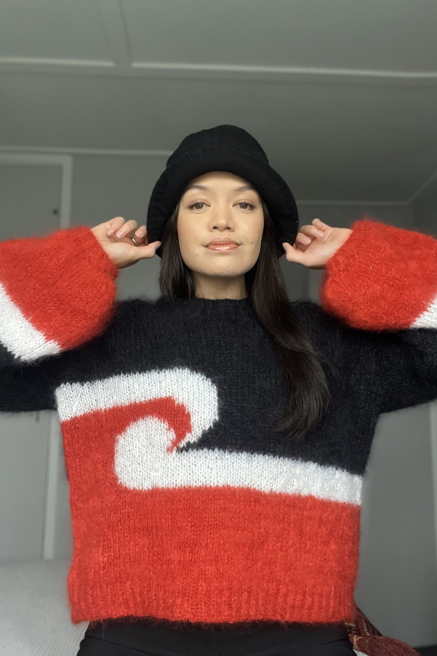 New Zealand artist and academic Aorangi Kora makes garments under the moniker Crochet Bae. Here she wears the distinctive Tino Rangatiratanga poraka (sweater).