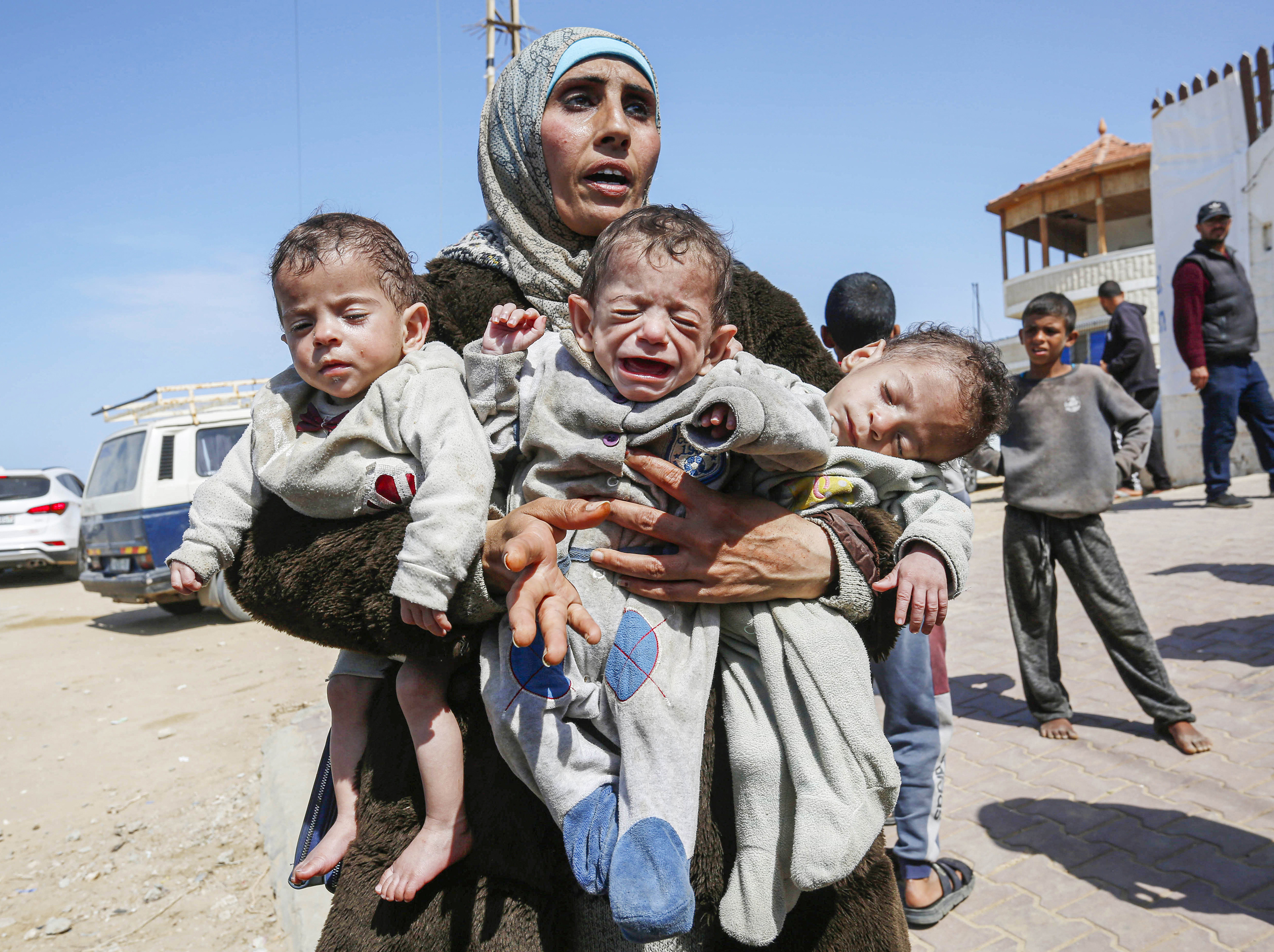 Palestinian woman Nuzha Avda, who lost her home after Israel's attacks and took shelter at Shifa Hospital, holds her triplets in her arms after the hospital was hit multiple times in Israel's attacks in Gaza Strip on March 21. Photo / Getty Images