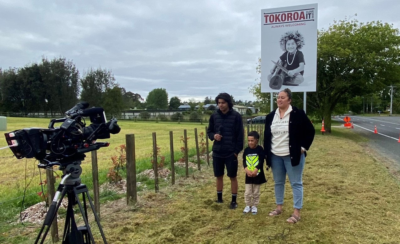 BMX champ Tyrell Taylor (left), McGregor Manu (centre) and Tokoroa sports advocate Sami Kaitai in front of McGregor's sign for the Breakfast TV story.