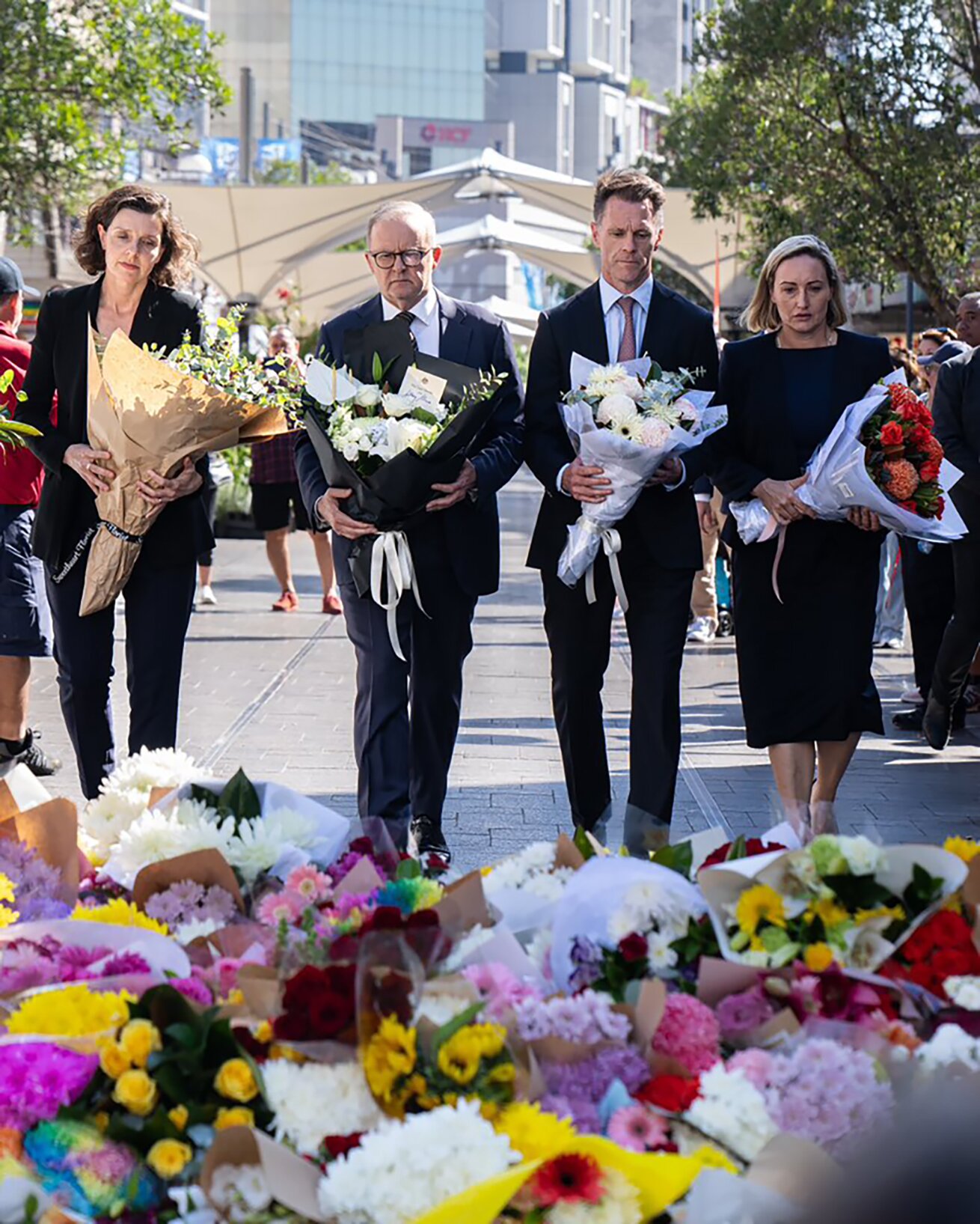 Australian Prime Minister Anthony Albanese (second from left) places flowers for the victims of the Bondi Junction Westfield tragedy at an impromptu memorial. Photo / The Office of Anthony Albanese