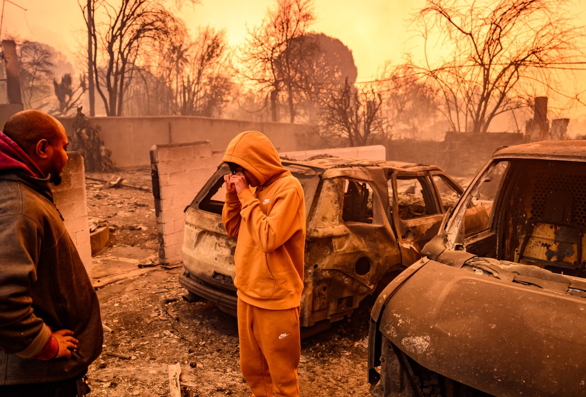 Lebron Jones wipes his eyes while viewing his burned home. Photo / AFP