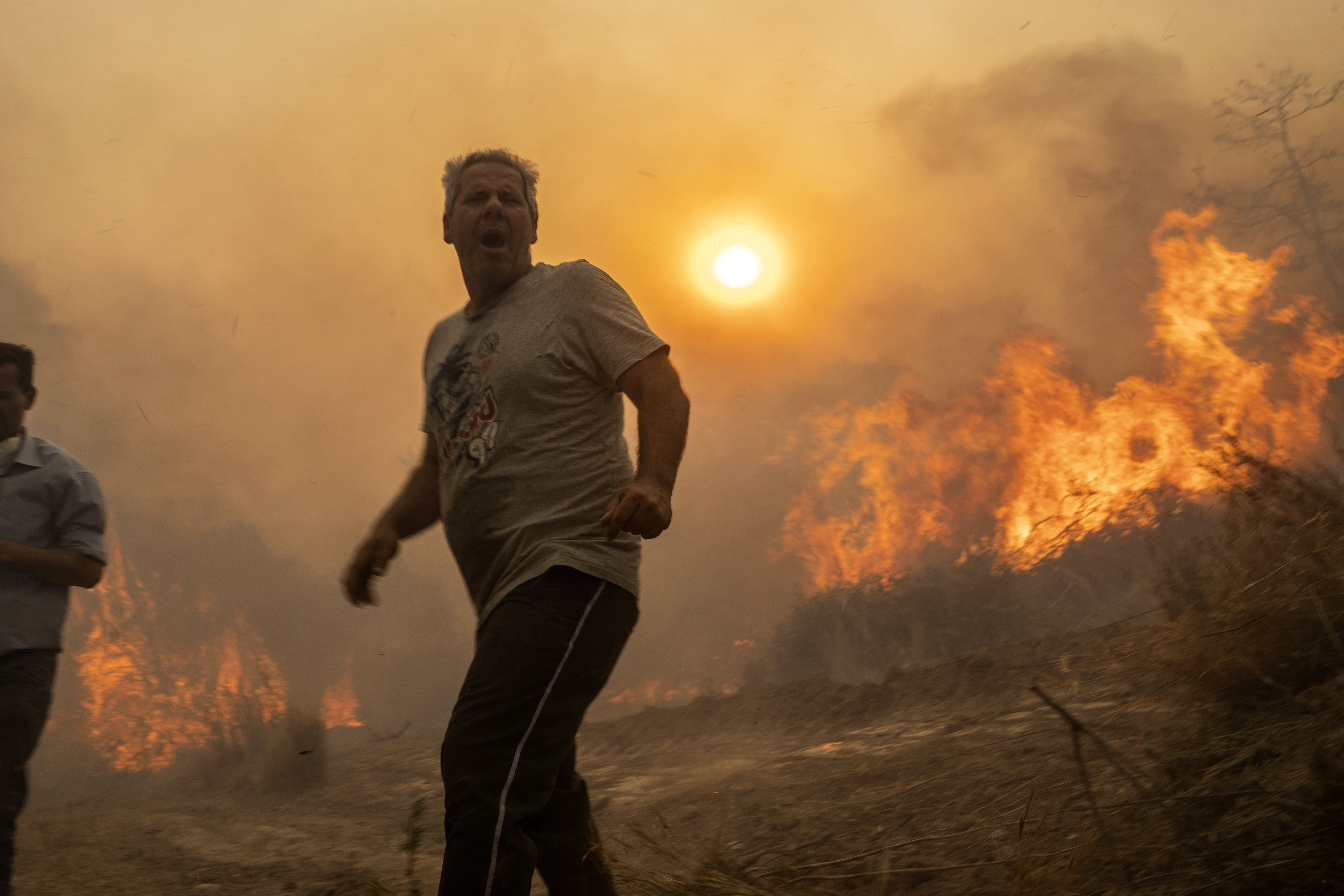 A local reacts as the flames burn trees in Gennadi village, on the Aegean Sea island of Rhodes, southeastern Greece. Photo / AP