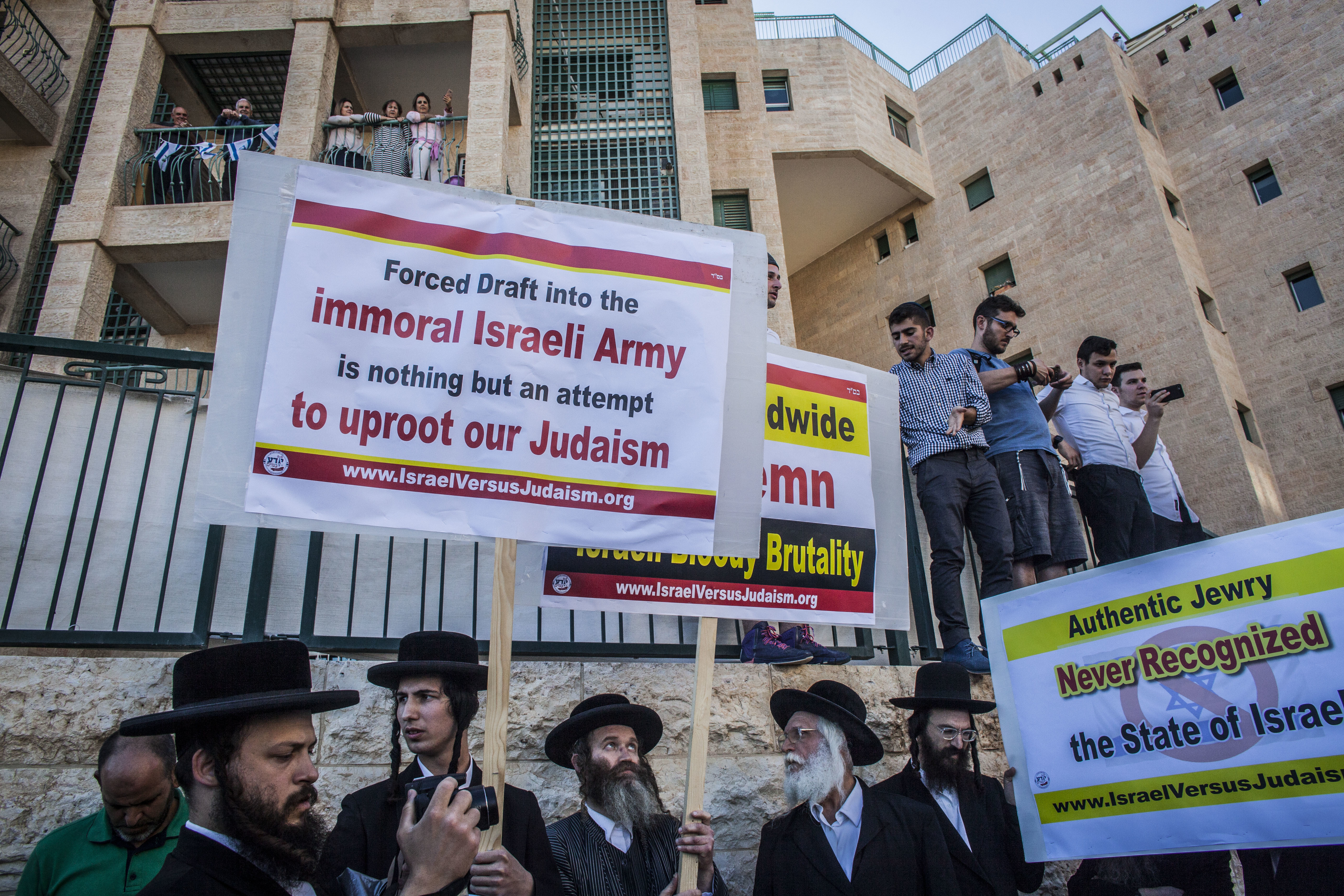 Ultra orthodox Jewish men wave signs and chant outside the new US Embassy in Jerusalem. Photo / AP 