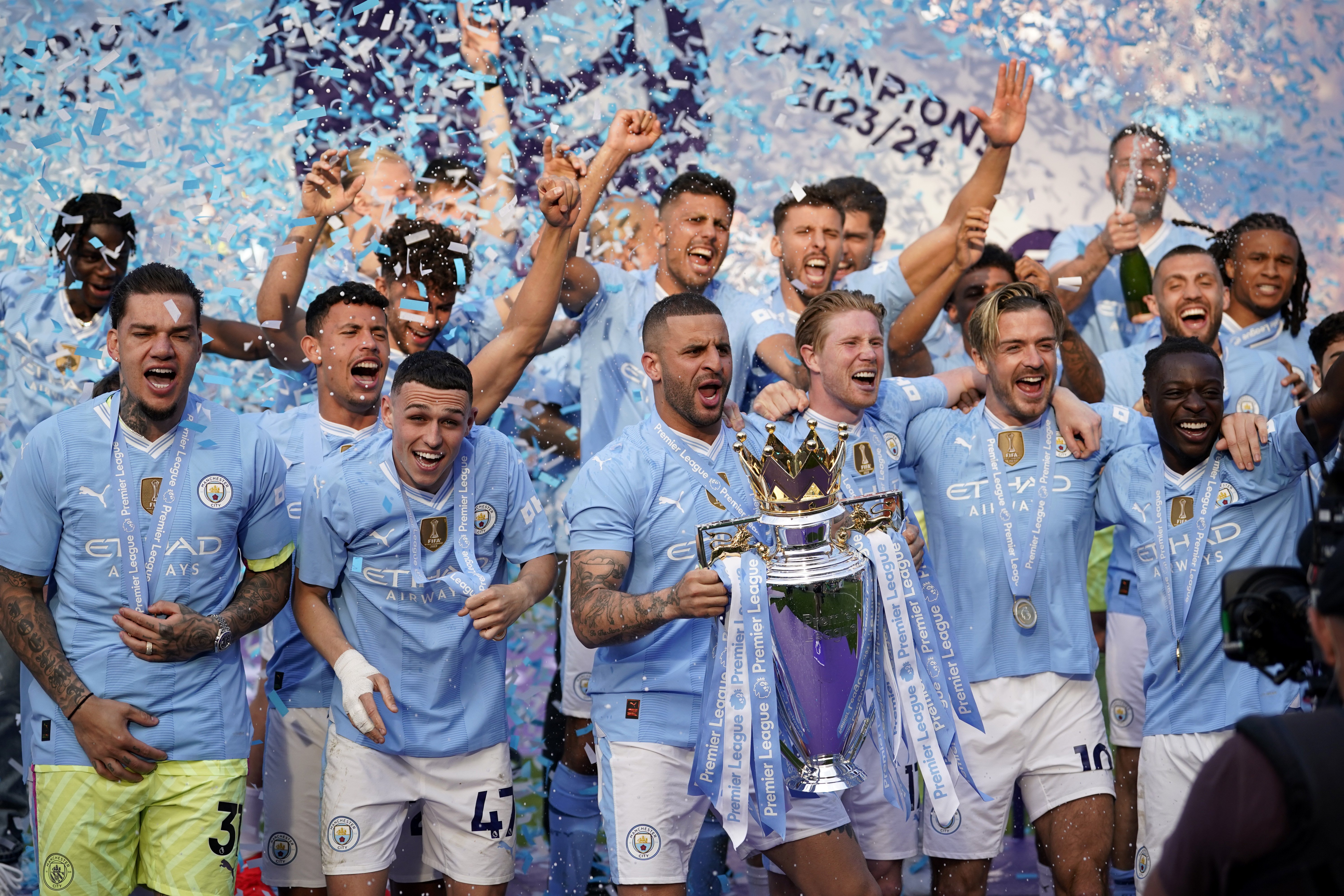 Manchester City's Kyle Walker celebrates with the Premier League trophy the club claimed a fourth straight title. Photo / AP