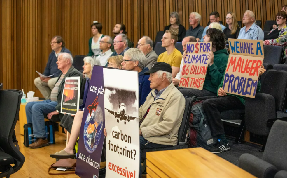 Protesters with signs at a Christchurch City Council meeting. Photo / Nate McKinnon, RNZ