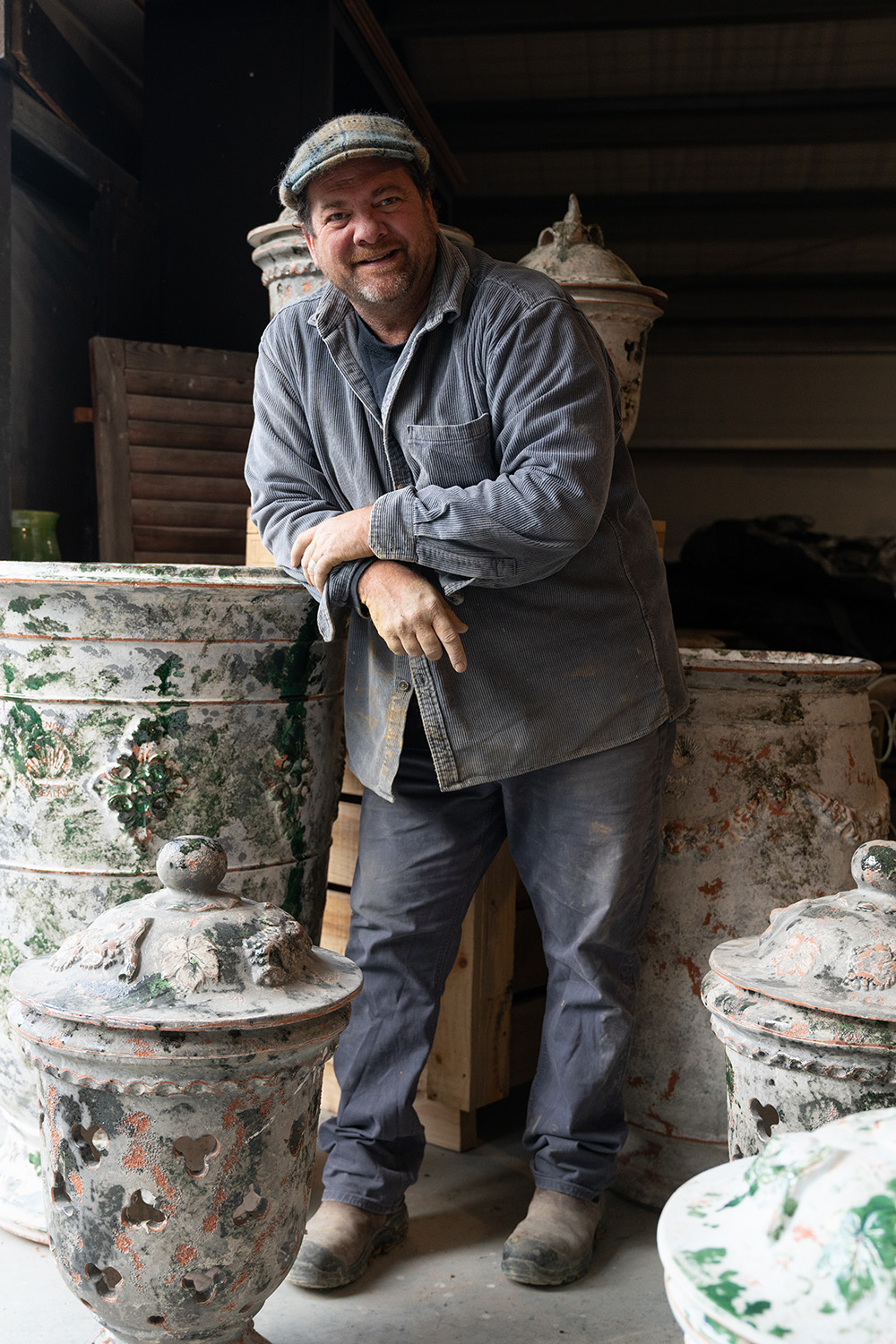 Yannick Fourbet stands with a collection of his pottery, in clay-covered corduroy and a Southern Lakes Tartan cheese cutter hat. Photo / Hyuma Kaneko