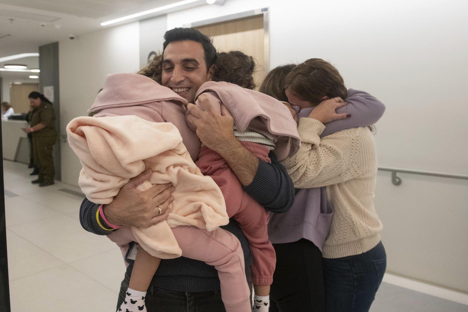 Aviv Asher, 2, her sister Raz Asher, 4, and mother Doron, react as they meet with Yoni, Doron's husband and their father, after they returned to Israel at the Schneider Children's Medical Centre. Photo / Schneider Children’s Medical Centre via AP