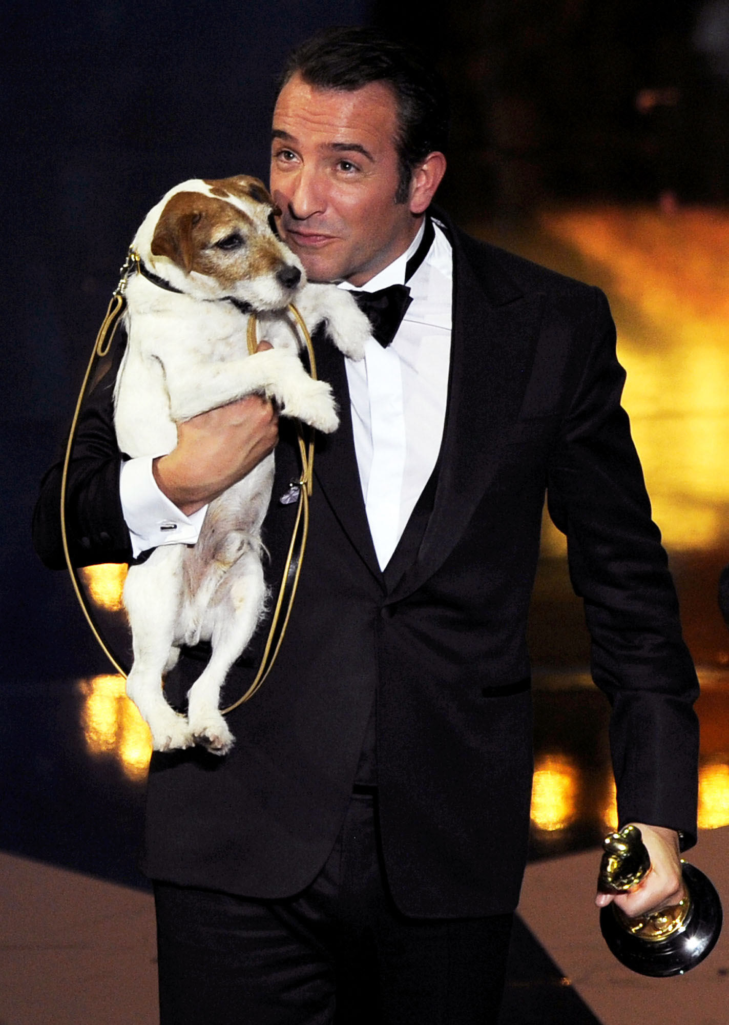 The Artist star Jean Dujardin holds Uggie the dog after accepting the Oscar for best picture in 2012. Photo / AP