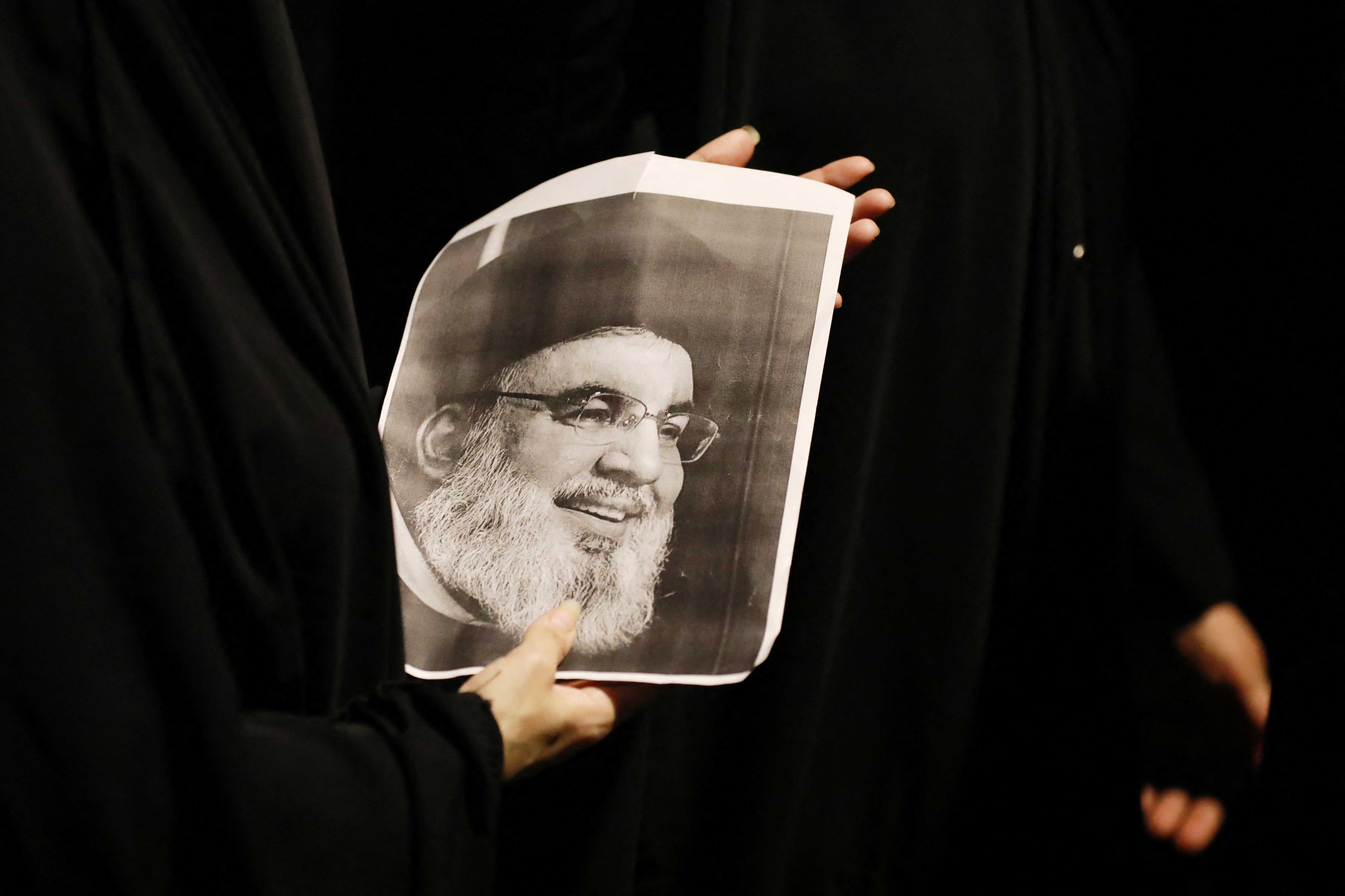 An Iraqi demonstrator holds a picture of Hassan Nasrallah, late leader of the Lebanese group Hezbollah, during a protest vigil near the suspension bridge leading to Baghdad's Green Zone on September 28. Photo / Murtaja Lateef / AFP