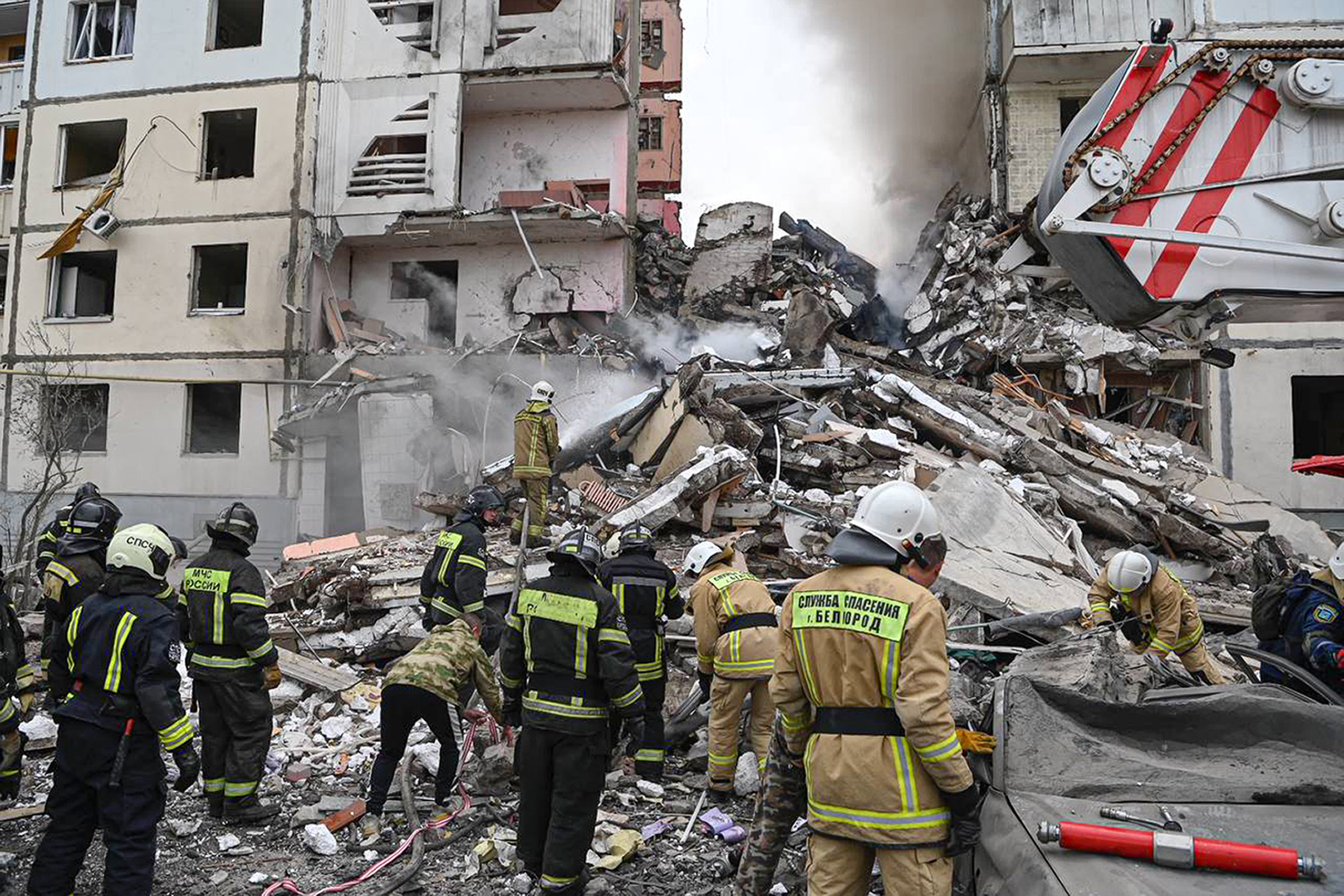 Russian emergency personnel at the scene of a partially collapsed block of flats after a missile attack in the Russian city of Belgorod, Russia. Photo / AP
