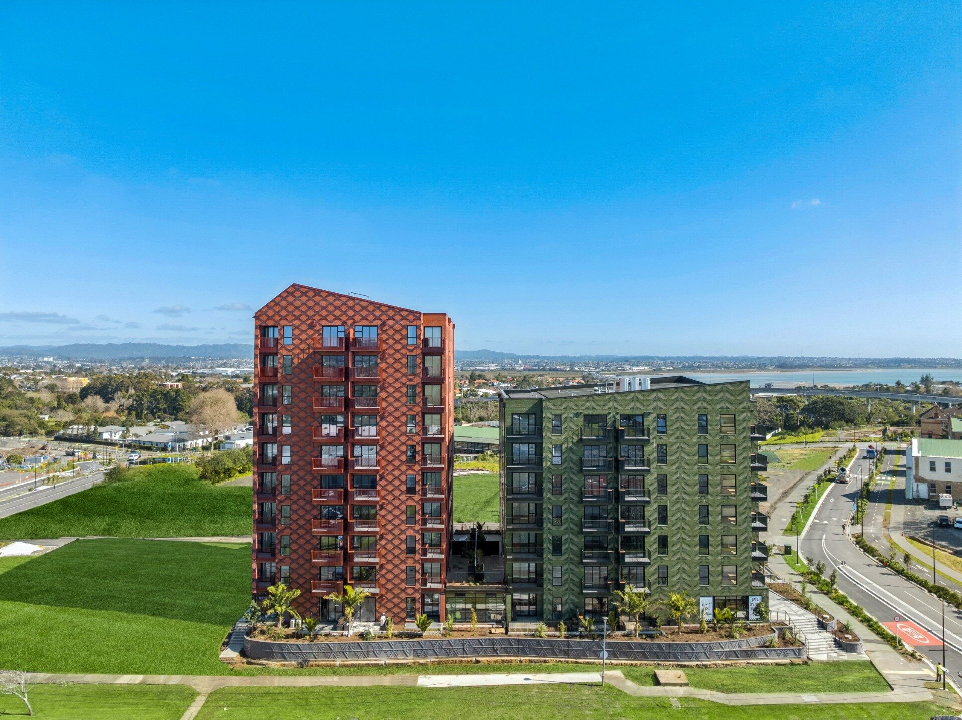 Ockham Residential and five-iwi collective Marutūāhu have developed the red Whetū apartment block (left) and the green Toi (right) at Pt Chevalier in Auckland. This is on former Unitec land. Photo / Ockham
