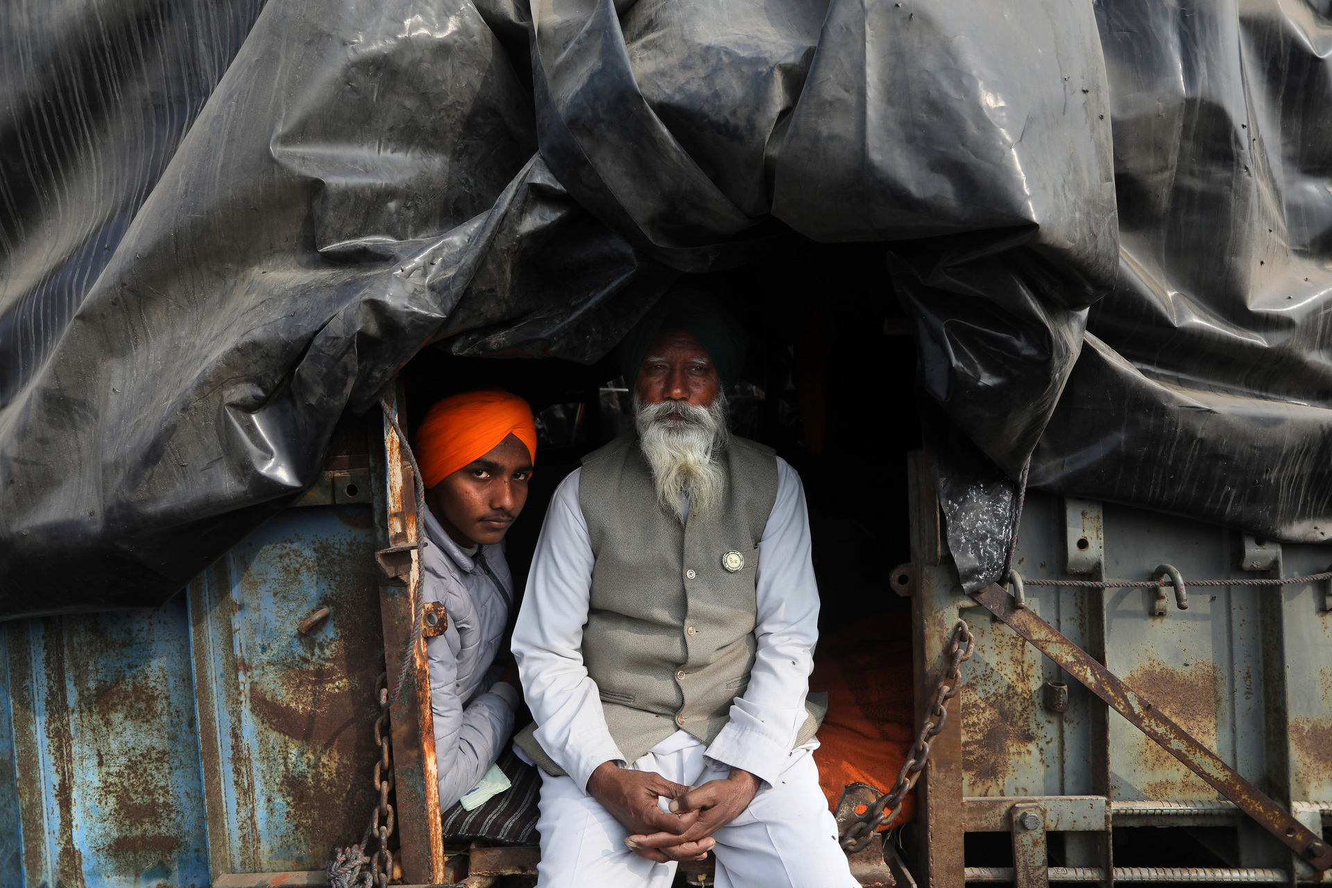 An elderly farmer sits with his grandson in the back of their tractor trailer as they join a protest blocking a highway at the Delhi- Haryana border. Photo / AP