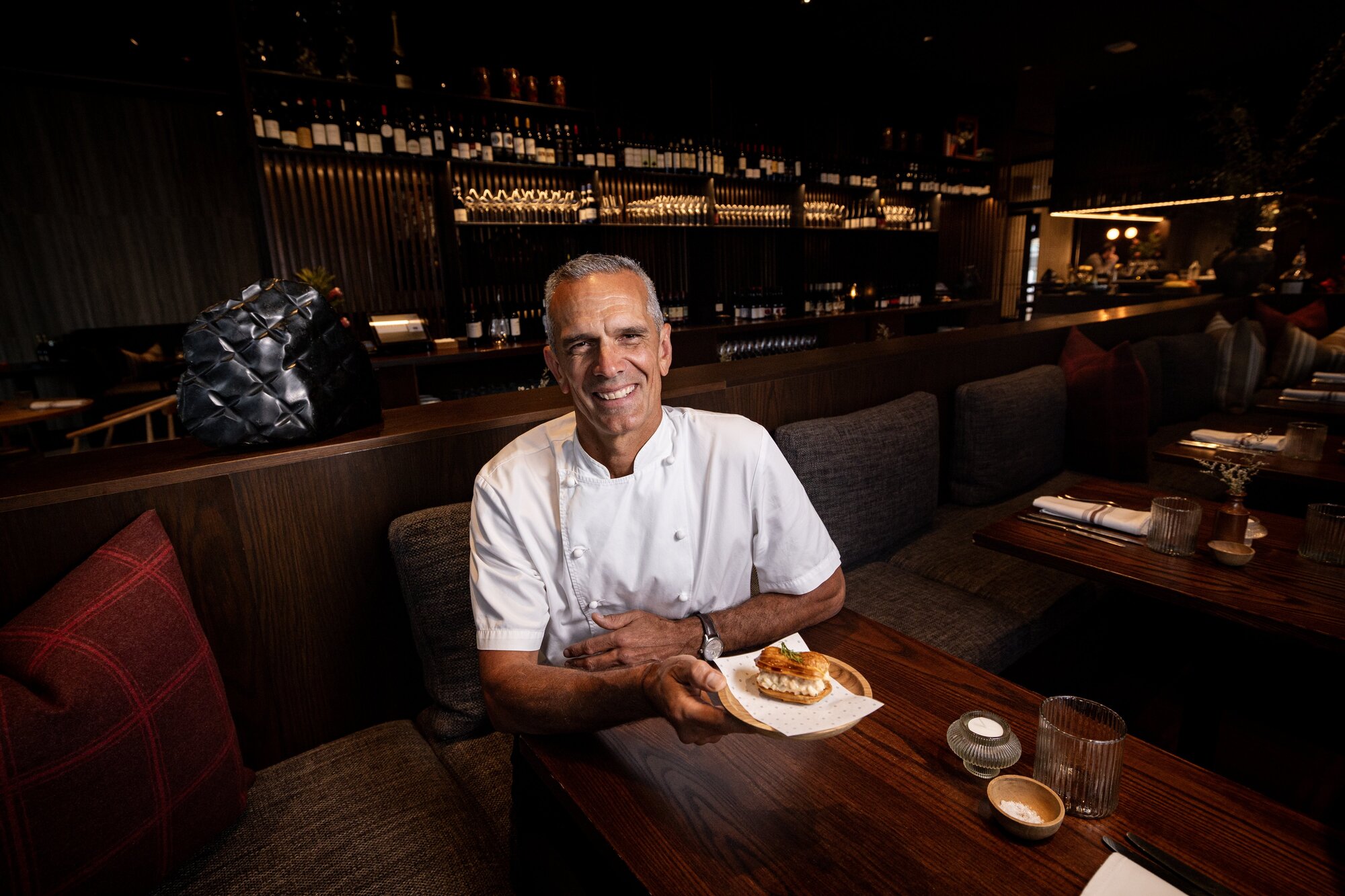 Josh Emett and the Onslow crayfish eclair – one of the 100 dishes named in the 2025 Auckland Iconic Eats list. Photo / Dean Purcell