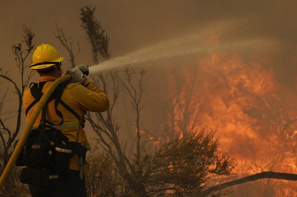 Jesse Vasquez, of the San Bernardino County Fire Department, hoses down hot spots from the Bobcat Fire. Photo / AP