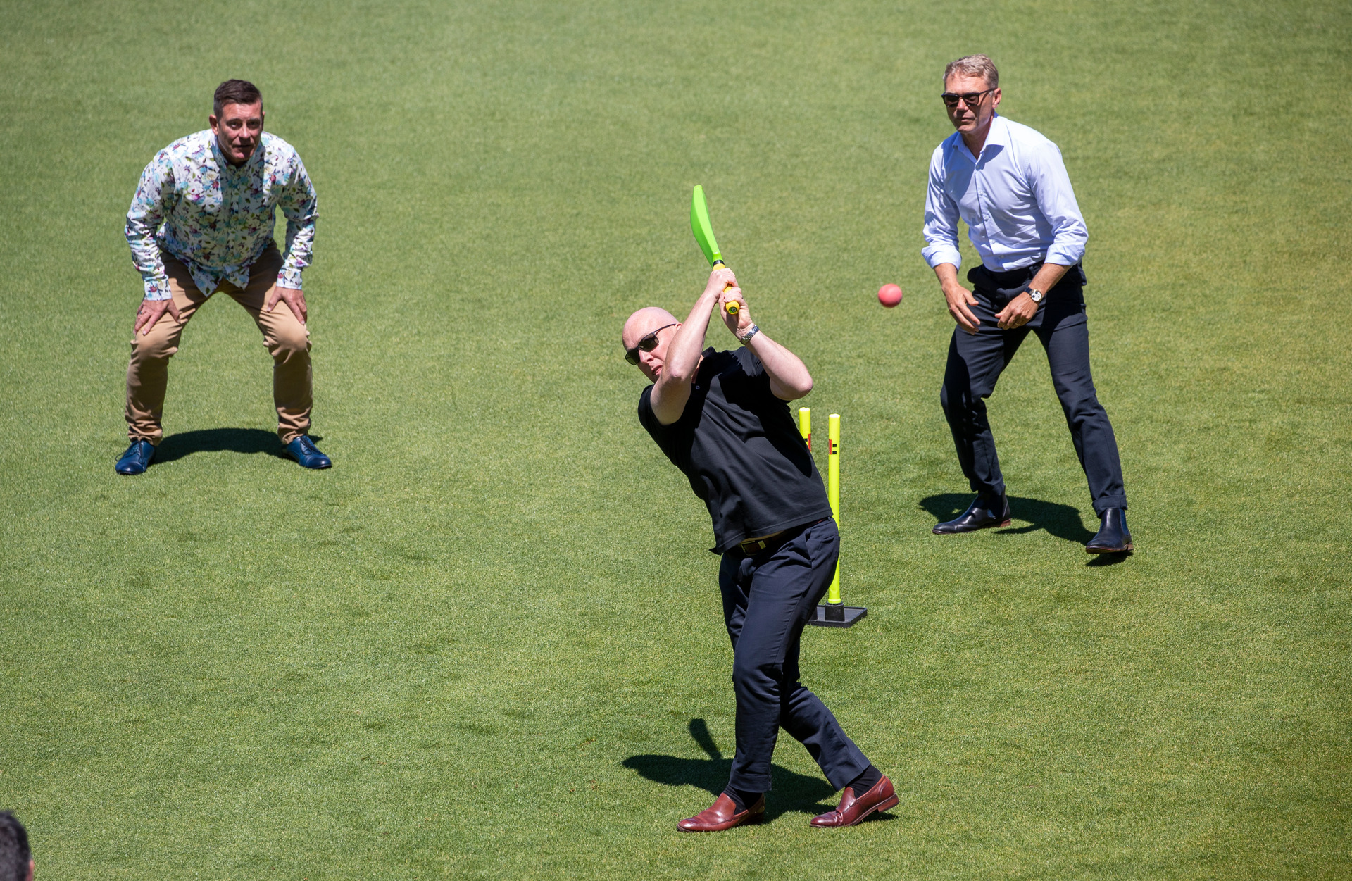 Michael Woodhouse, left, and Paul Goldsmith look on as Christopher Luxon hits a ball high into the stands during the National Party caucus retreat at the Basin Reserve. Photo / Mark Mitchell
