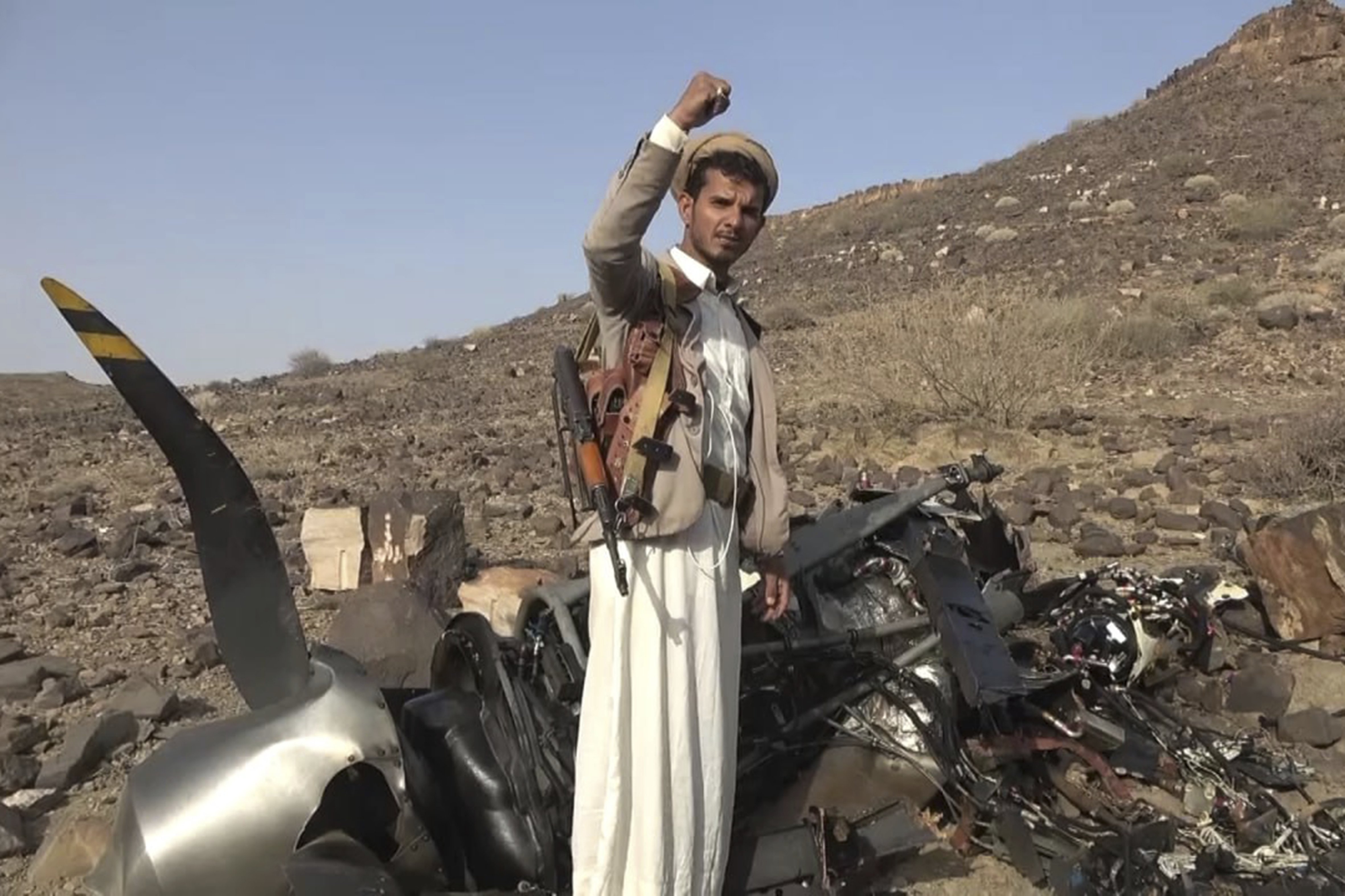 In this photo provided by the Houthi Media Office on Saturday, April 27, 2024, a Houthi fighter celebrates in front of what they say is the debris of an American MQ-9 aerial vehicle, shot down by the air defence forces of the Yemeni Armed Forces in Saada, Yemen the day prior. Photo / Houthi Media Office via AP