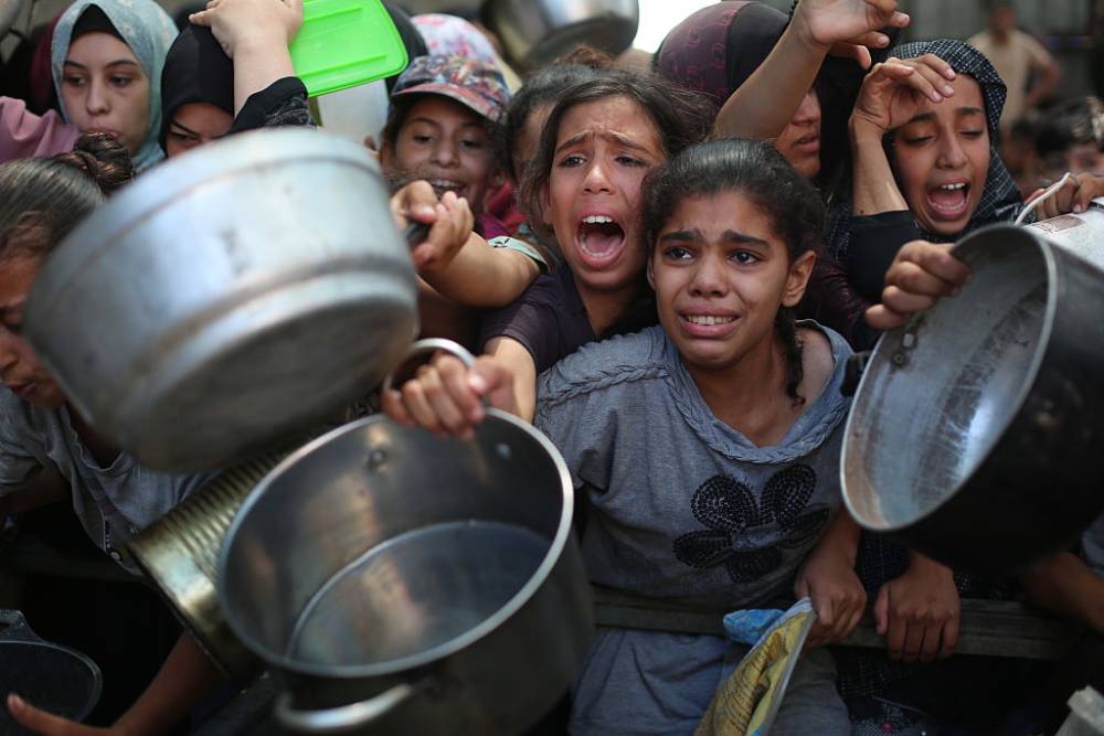 Palestinians wait to receive hot meals with their pots and pans in Deir Al Balah, Gaza. Photo / Anadolu via Getty Images