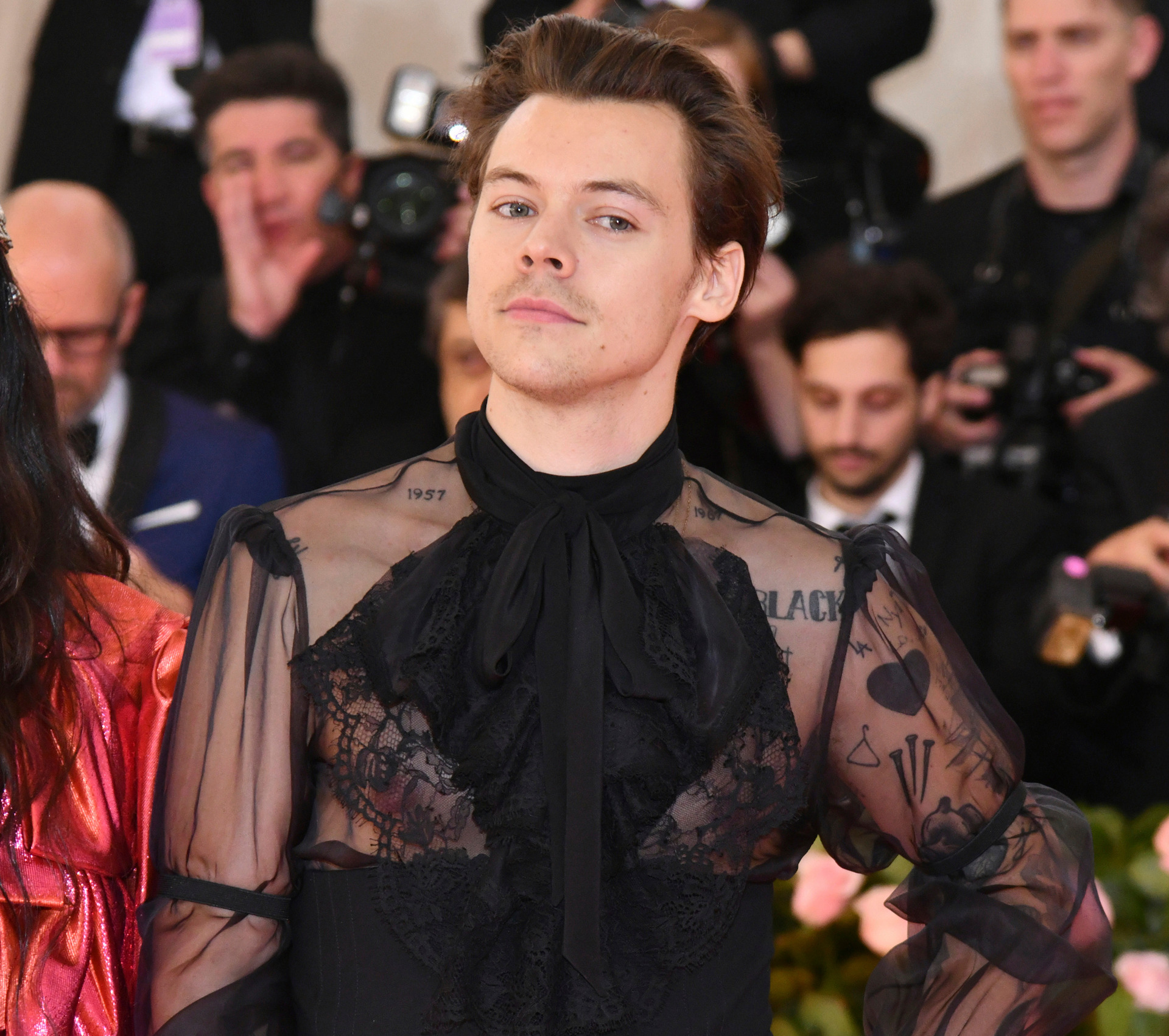 A new direction: Harry Styles wears one earring and a semi-sheer black  ruffled shirt as he embraces camp theme - NZ Herald