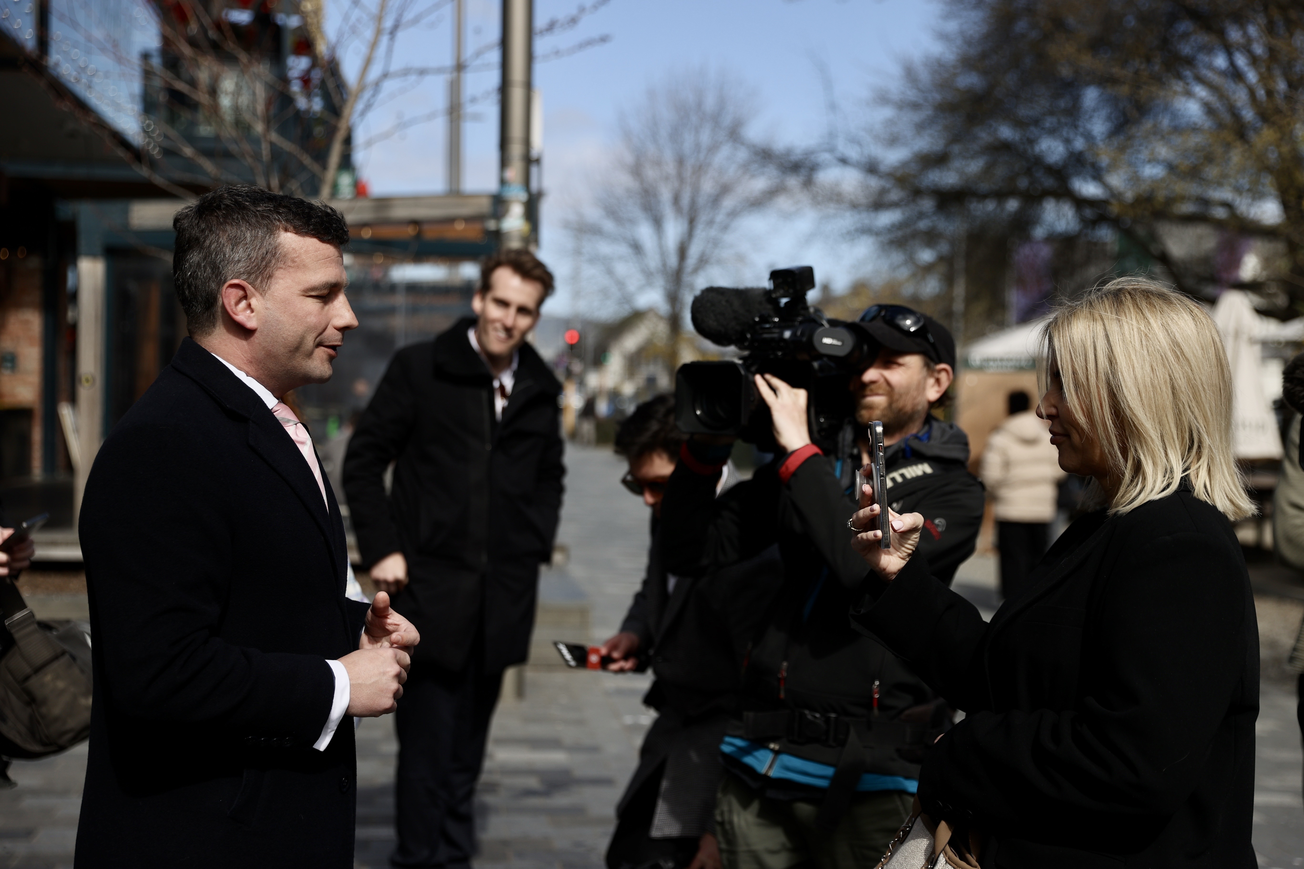 A few bystanders have gathered to listen as Seymour addresses the media. Photo / George Heard