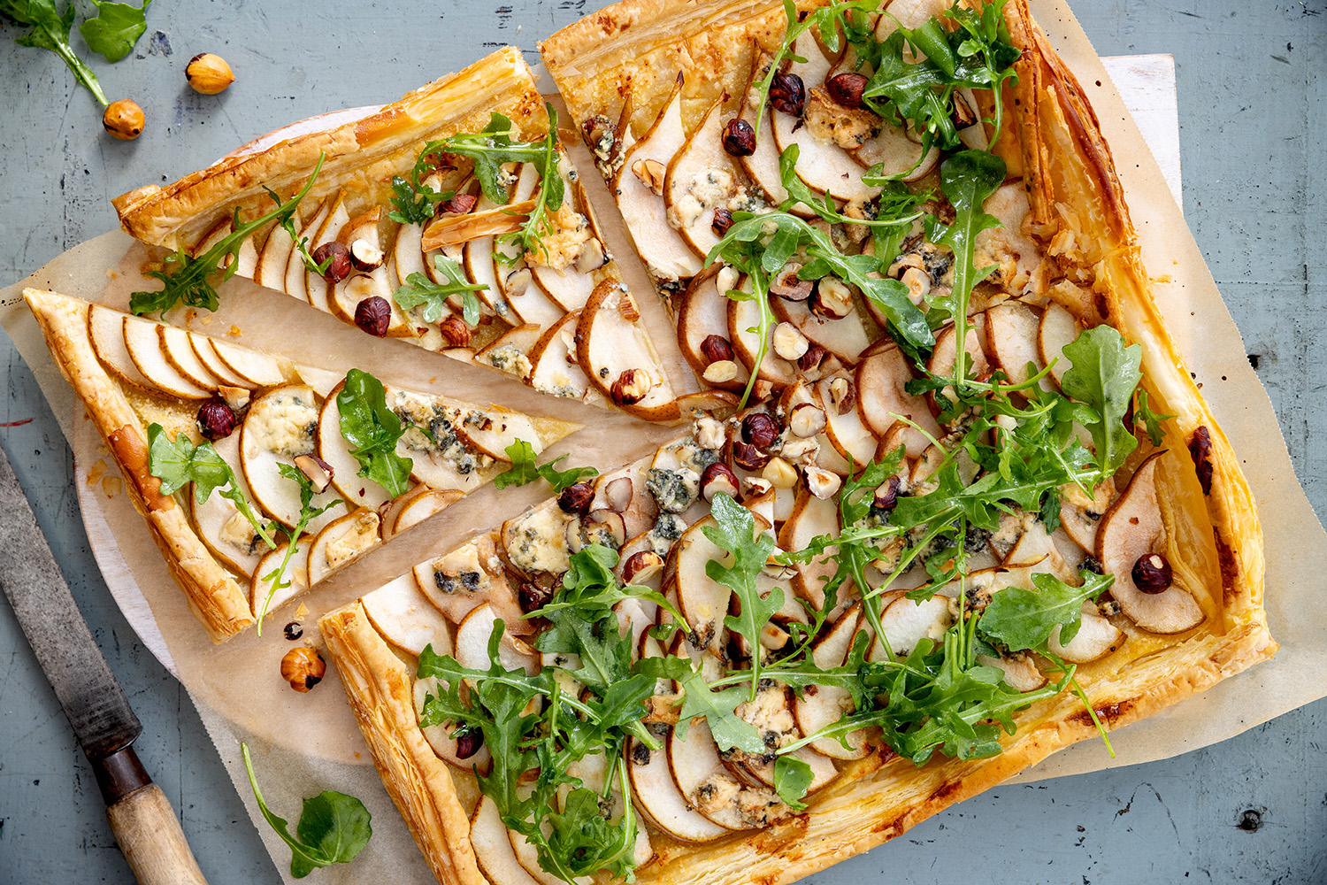 This pretty tart is topped with a scattering of rocket and crunchy roasted nuts. Photo / Babiche Martens