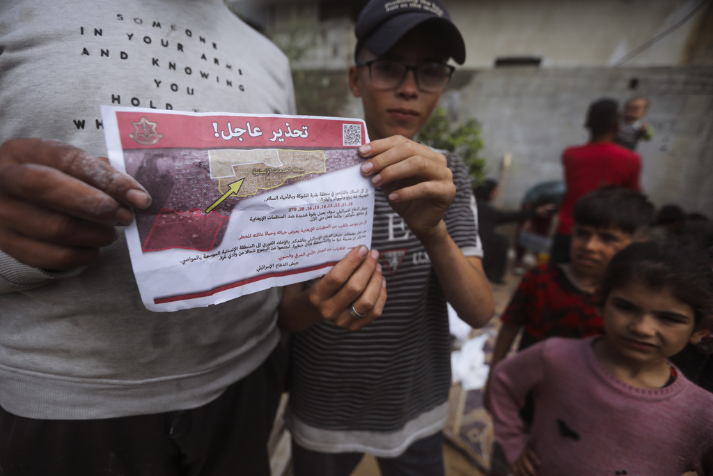 Palestinians hold leaflets dropped by Israeli planes calling on them to evacuate ahead of an Israeli military operation in Rafah, southern Gaza Strip on May 6. Photo / AP
