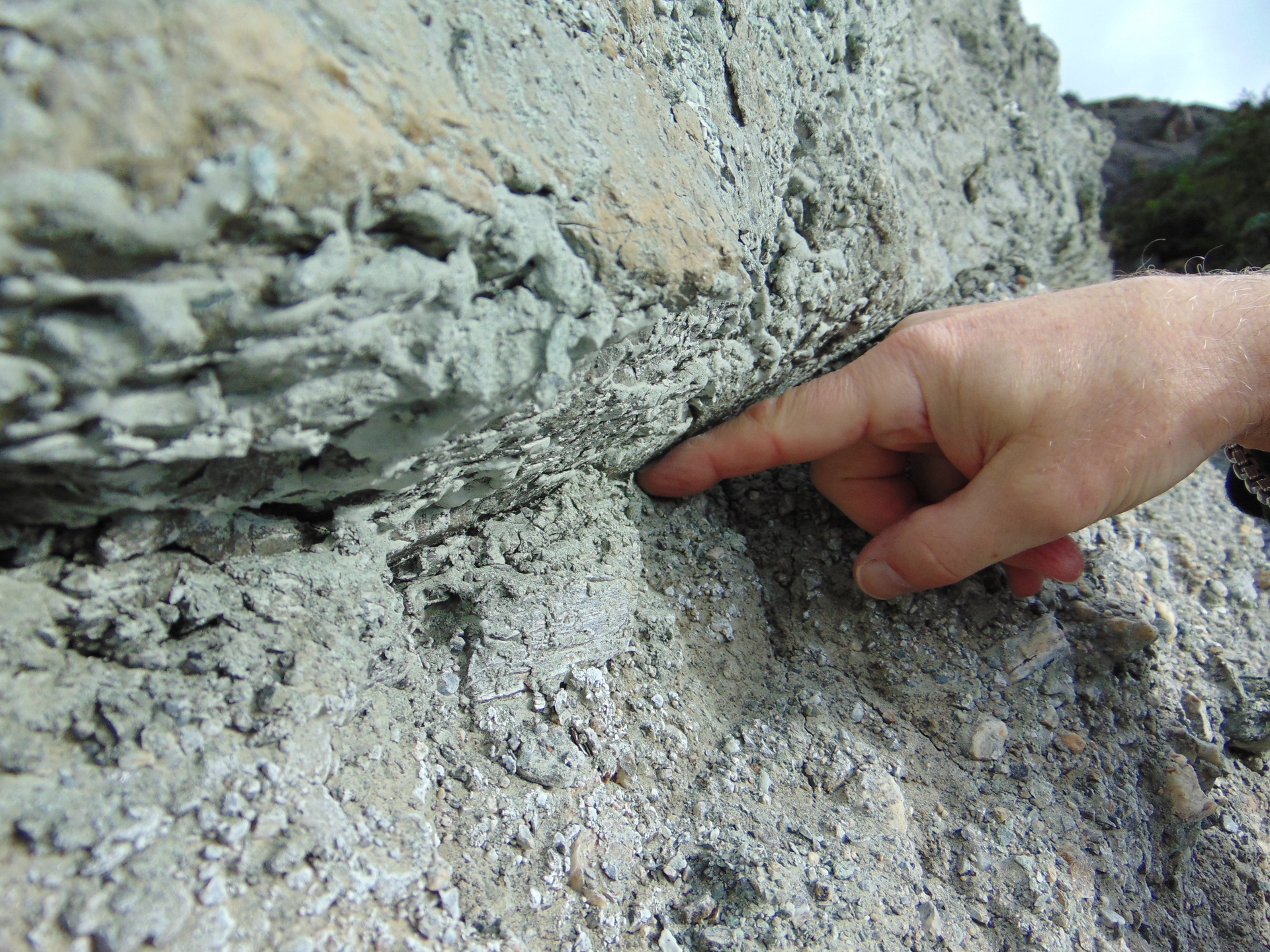 A visitor places a finger in rock amid the South Island's Alpine Fault, at the point where two tectonic plates divide. Photo / Supplied, Alpine Fault Tours