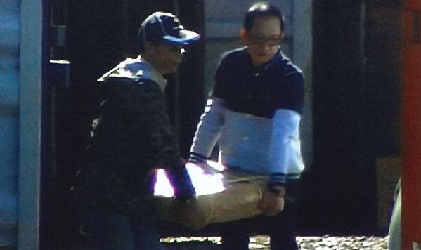 Chiu Tai Fi, left, and Ricky Leung caught on camera loading methamphetamine infused umbrella stands into a car. Photo / Supplied.