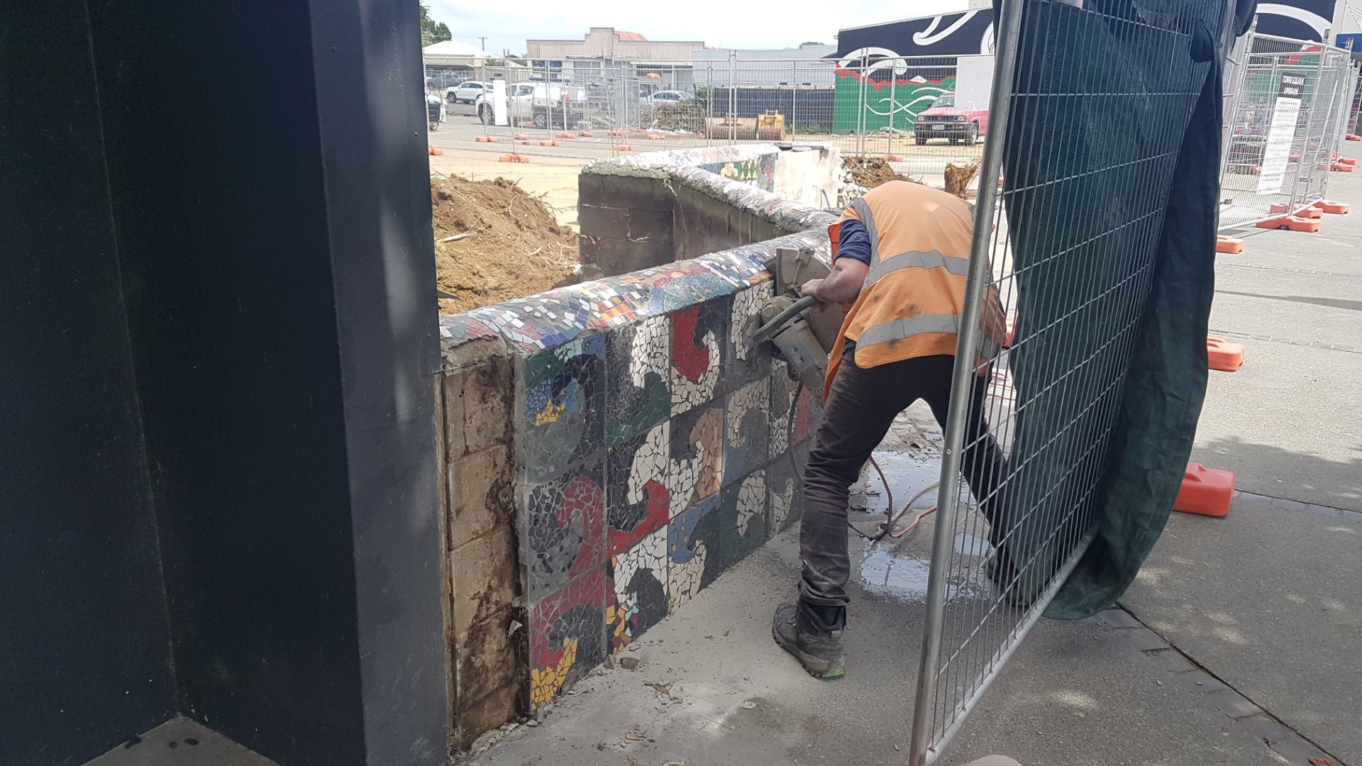 A contractor cuts into the Kaitāia mosaic wall ahead of the area being developed into a town square