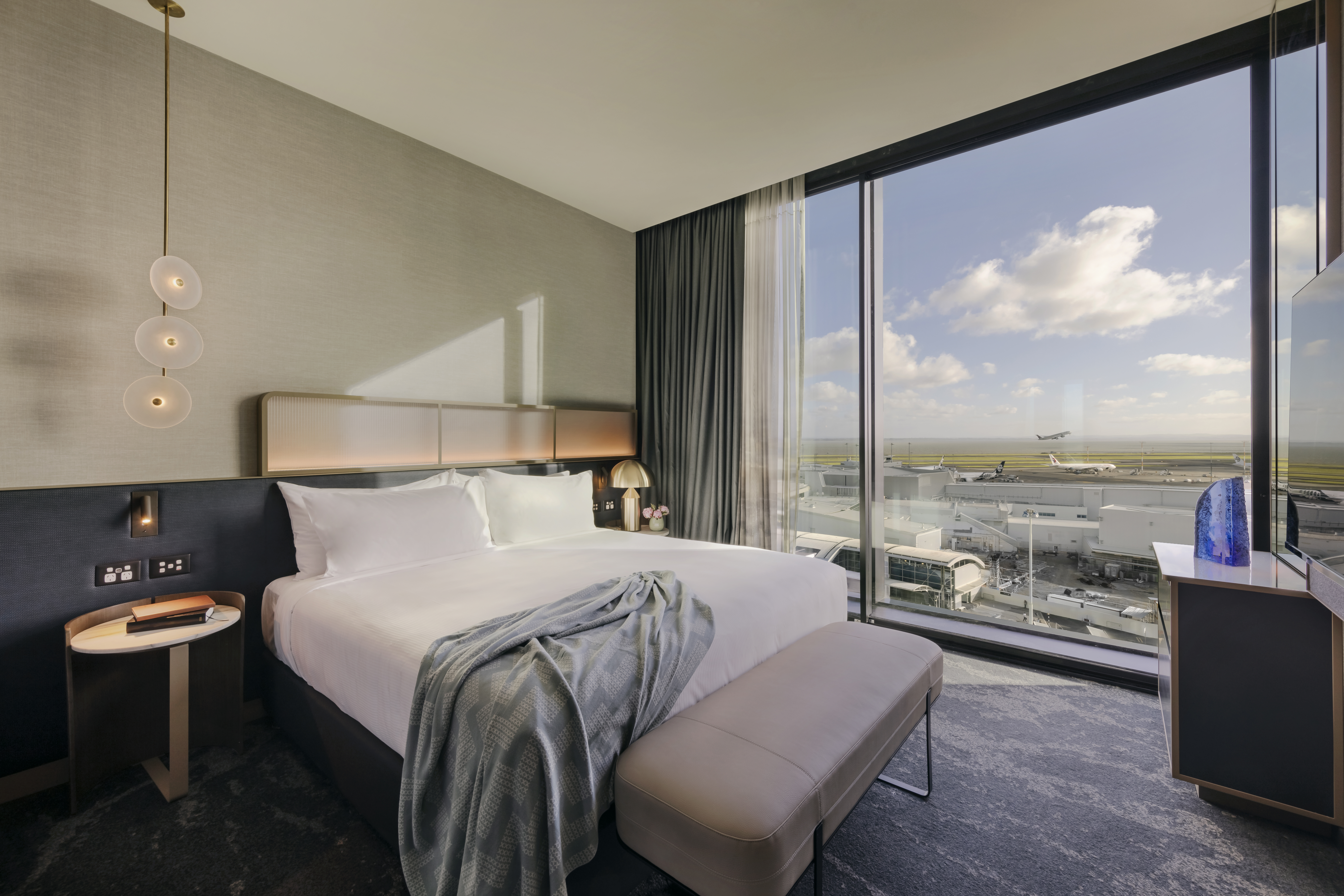 Te Arikinui Pullman Auckland Airport Hotel rooms have sound-proofed floor-to-ceiling windows.
