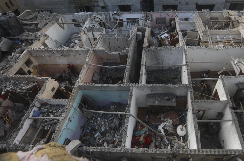 Palestinians look at the destruction after an Israeli strike on a residential building in Rafah, Gaza Strip. Photo / AP