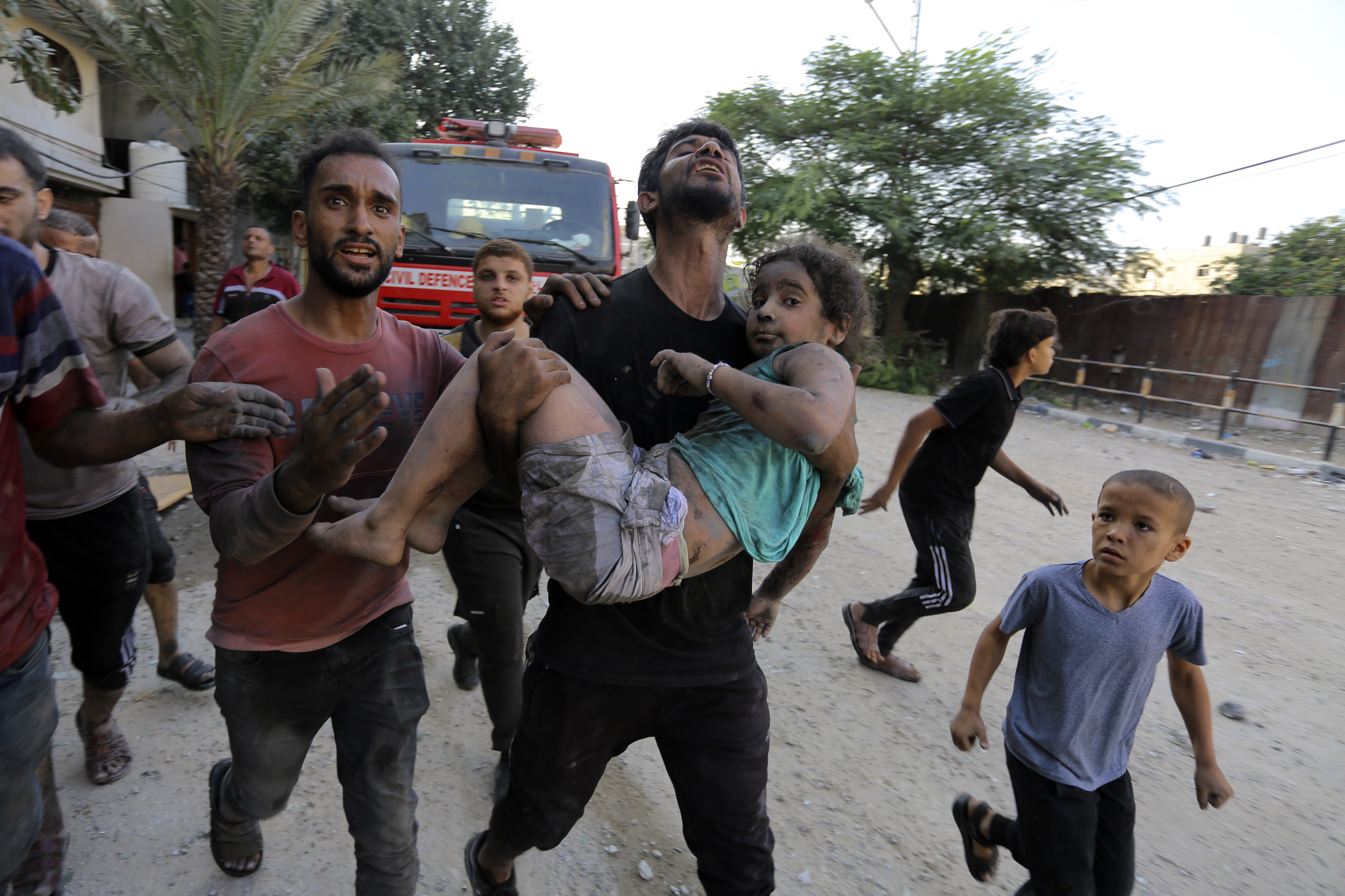 Palestinians carry a wounded girl after being rescued from under the rubble of buildings that were destroyed by Israeli airstrikes in Jabaliya refugee camp, northern Gaza Strip. Photo / AP