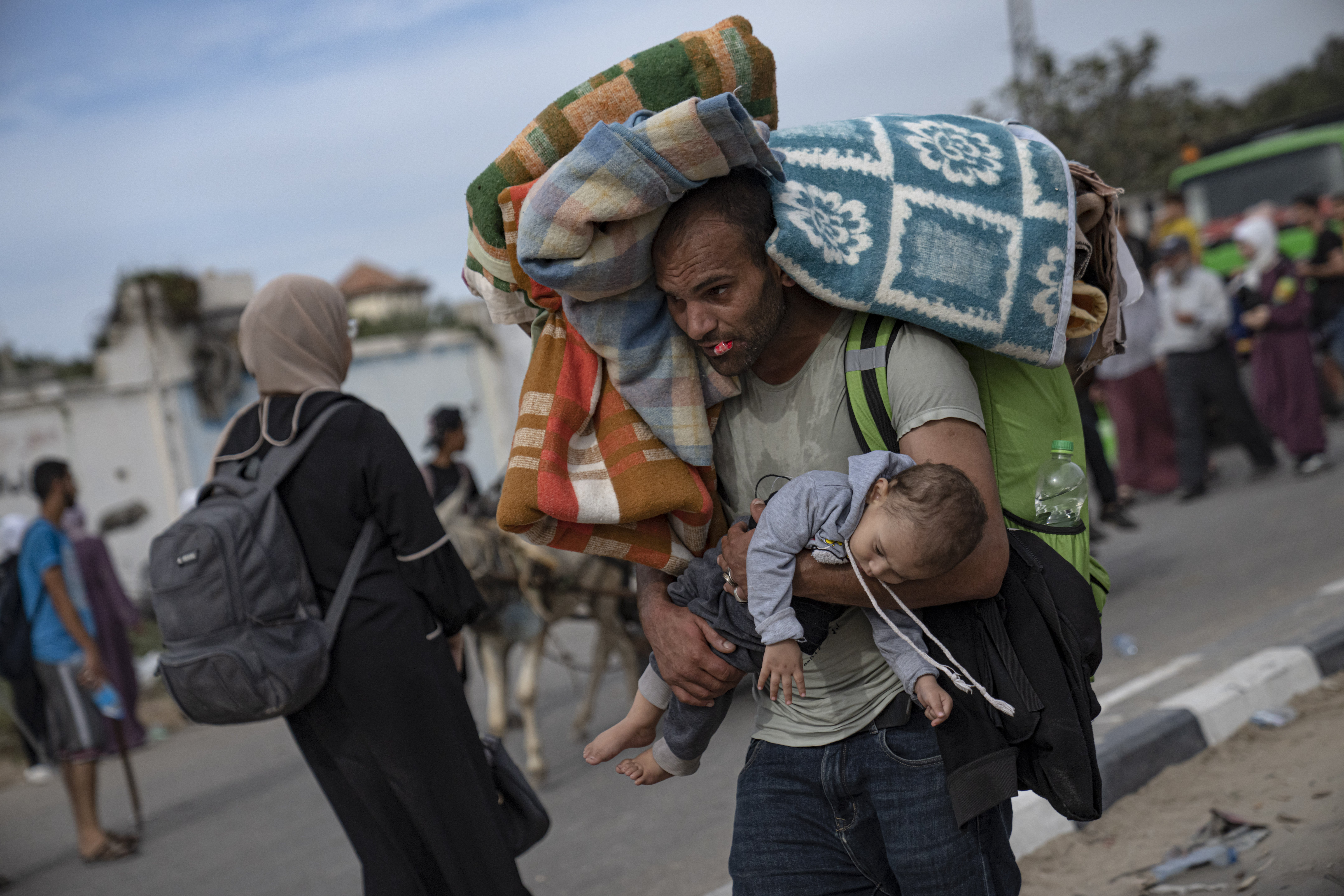 A Palestinian man flees with a child to the southern Gaza Strip on Salah al-Din Street in Bureij on November 11. Photo / AP