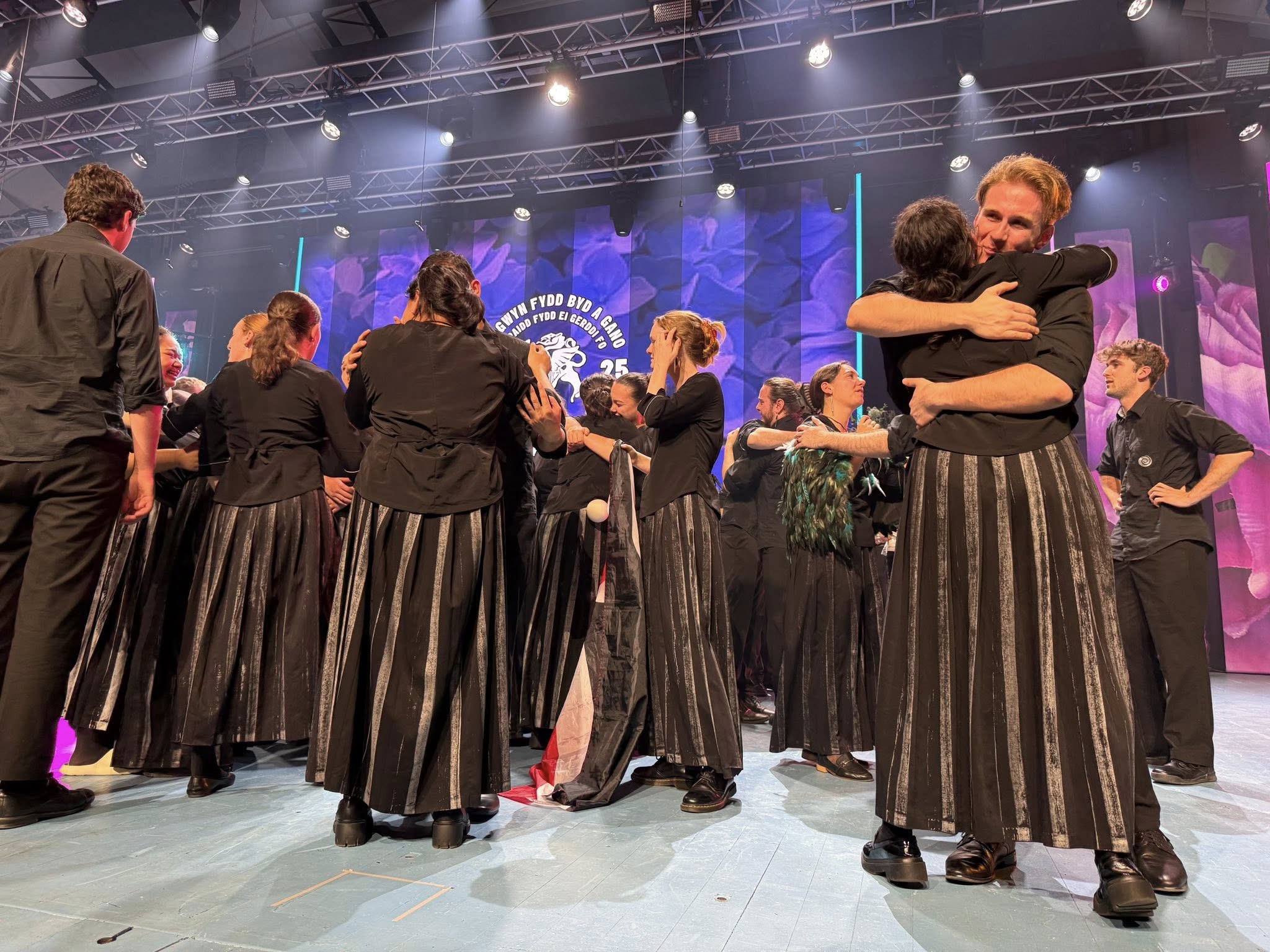 The NZ Youth Choir celebrates on-stage after their win.