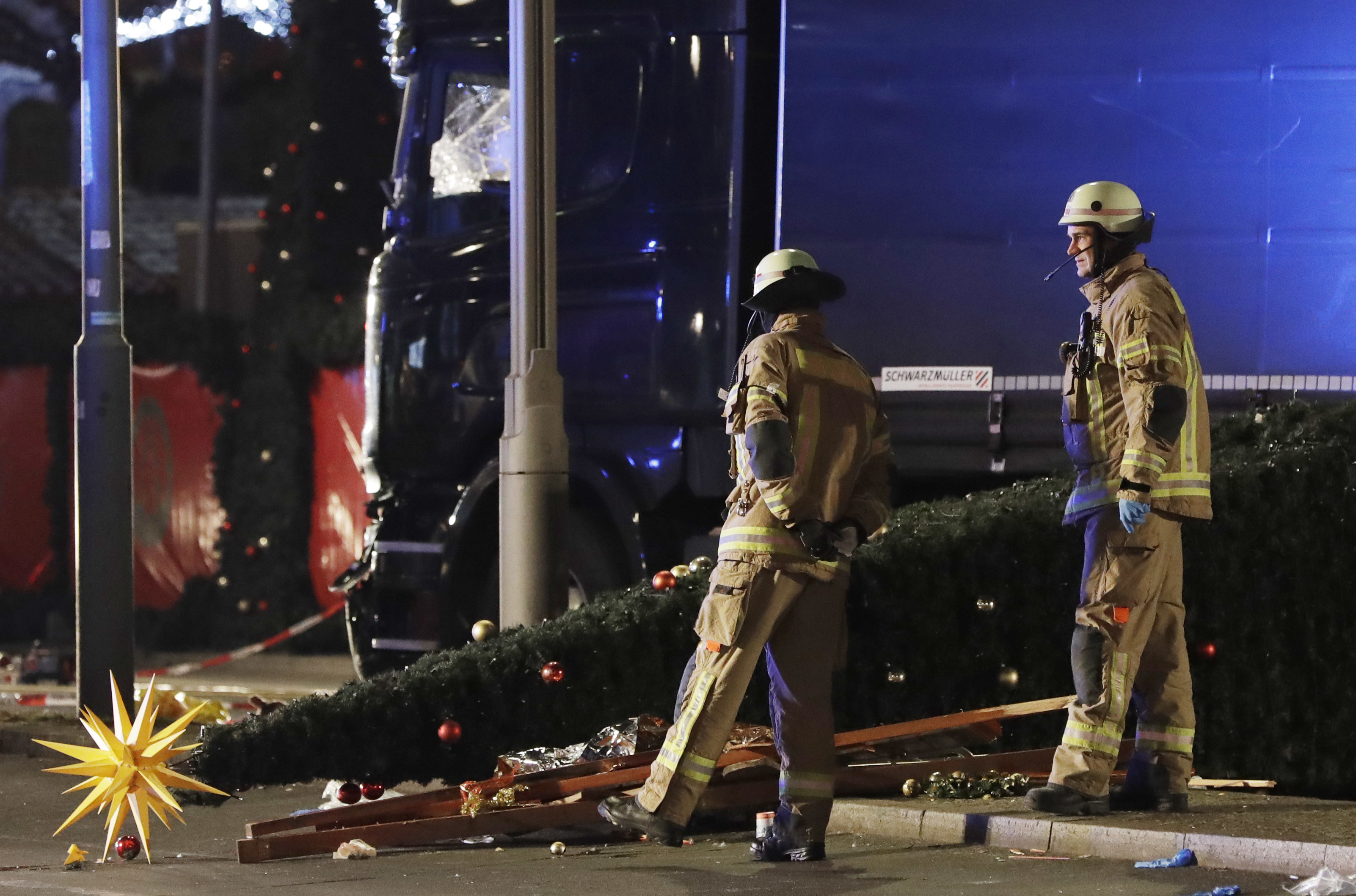 Firefighters look at a toppled Christmas tree after a truck ran into a crowded Christmas market. Photo / AP
